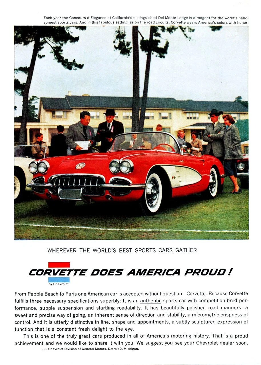 Photograph of a vintage red and white Chevrolet Corvette convertible at a car show with people admiring it, some holding papers, and a large building in the background.