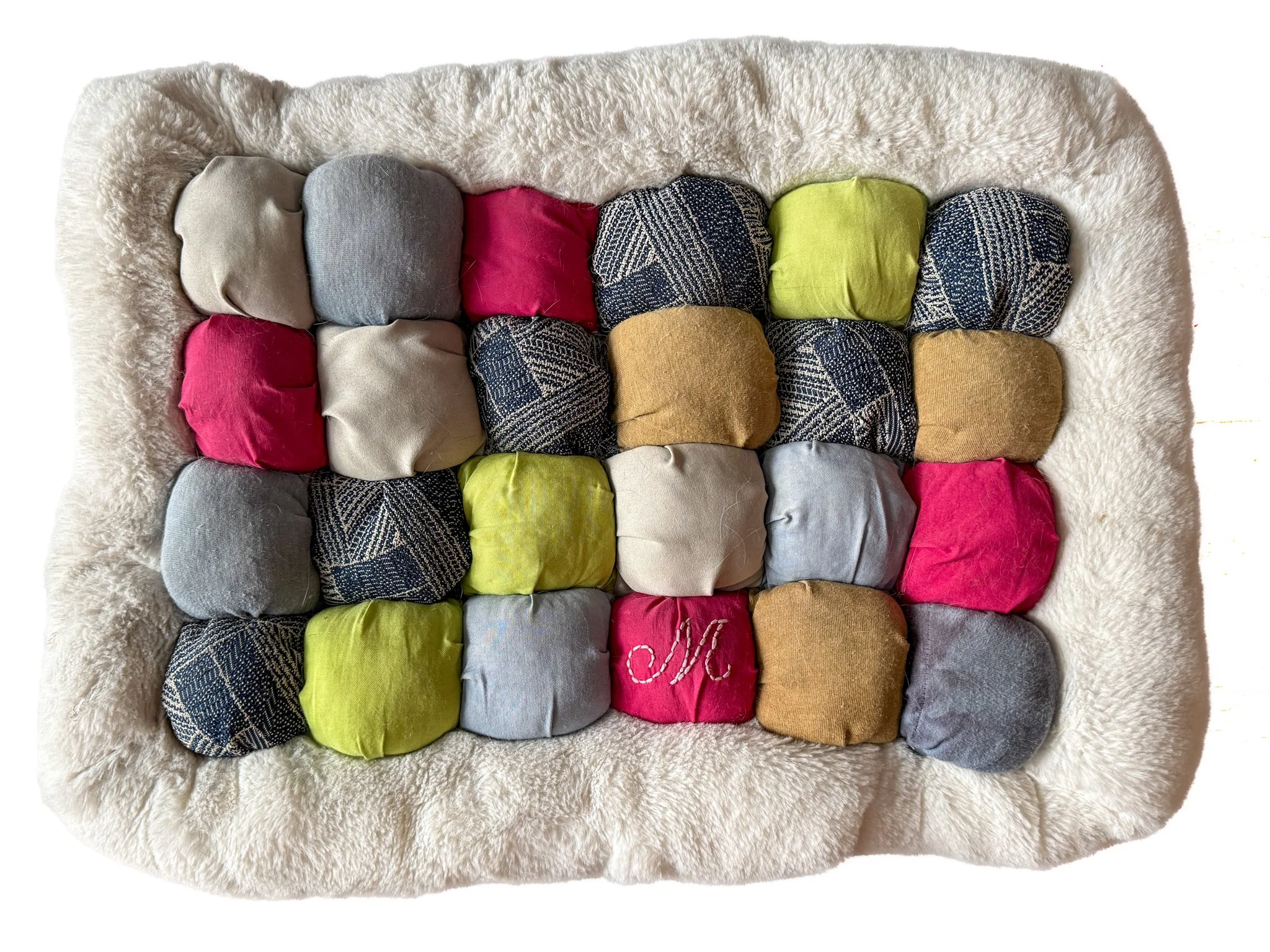 Bed for Margo, fabric from old shirts and clothes, fluffy white fabric and blue backing fabric from my childhood dog, Luke’s bed, polyfil with fur from Luke, hand embroidery, hand and machine sewn, 12"x16"