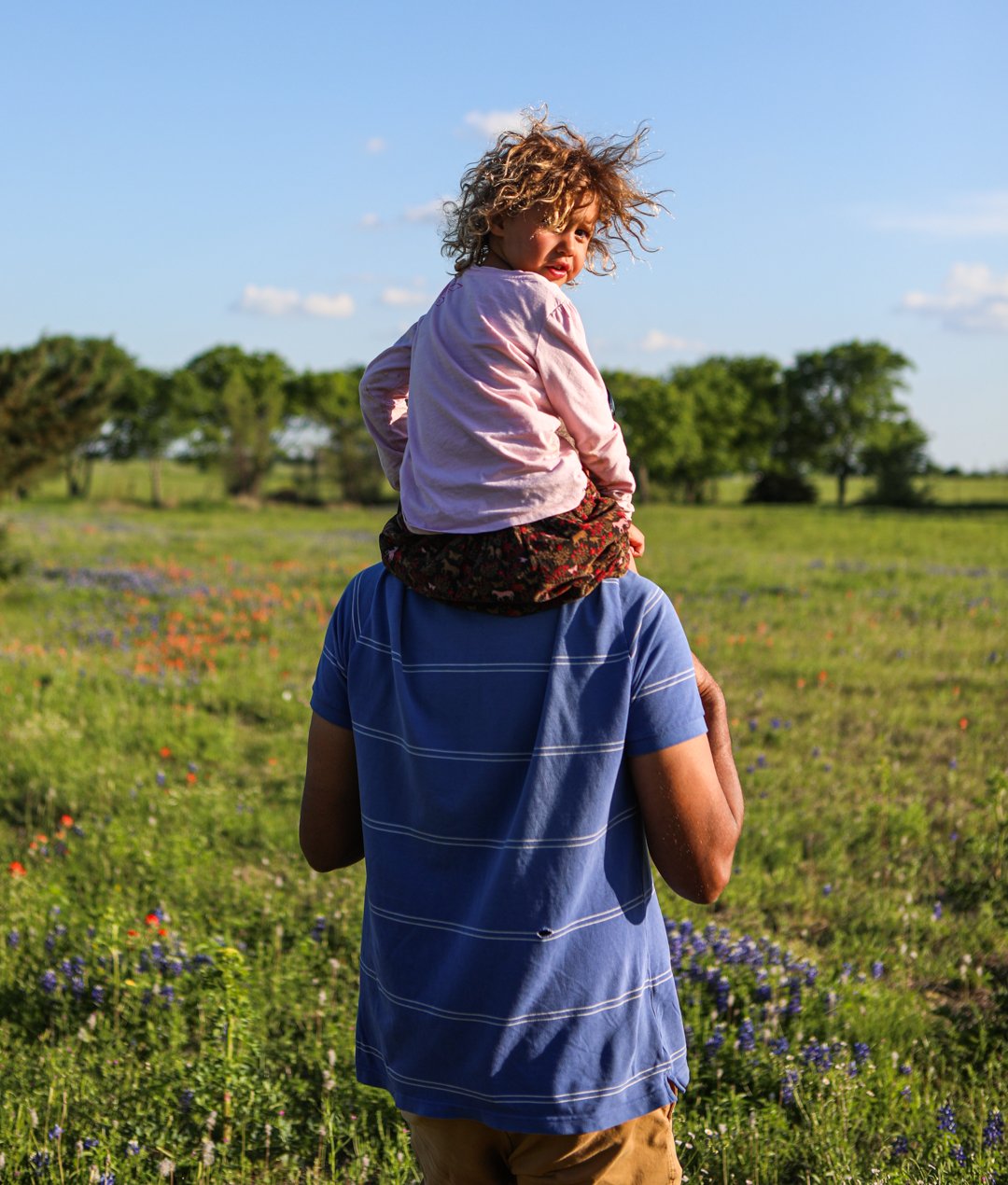A child that lives on the land of the Branch Davidian compound sits on her father's shoulders.