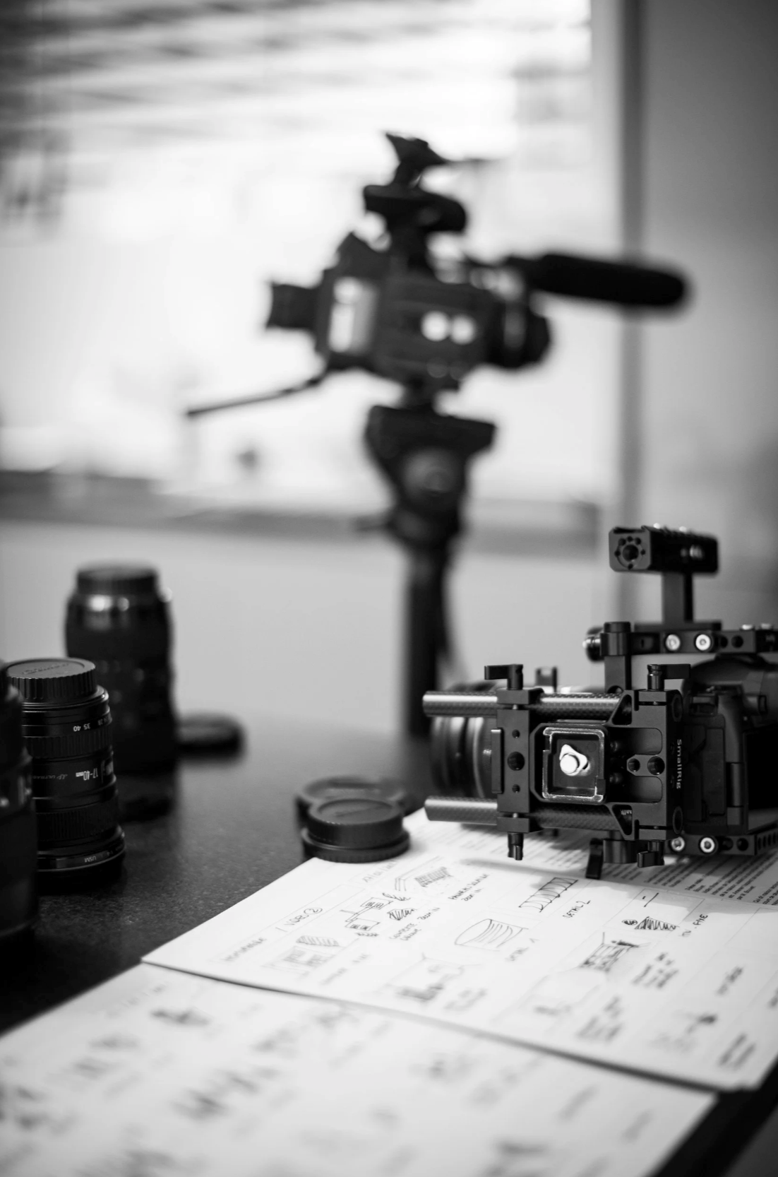 Professional camera equipment and lenses on desk for video production planning — Orange County video production company