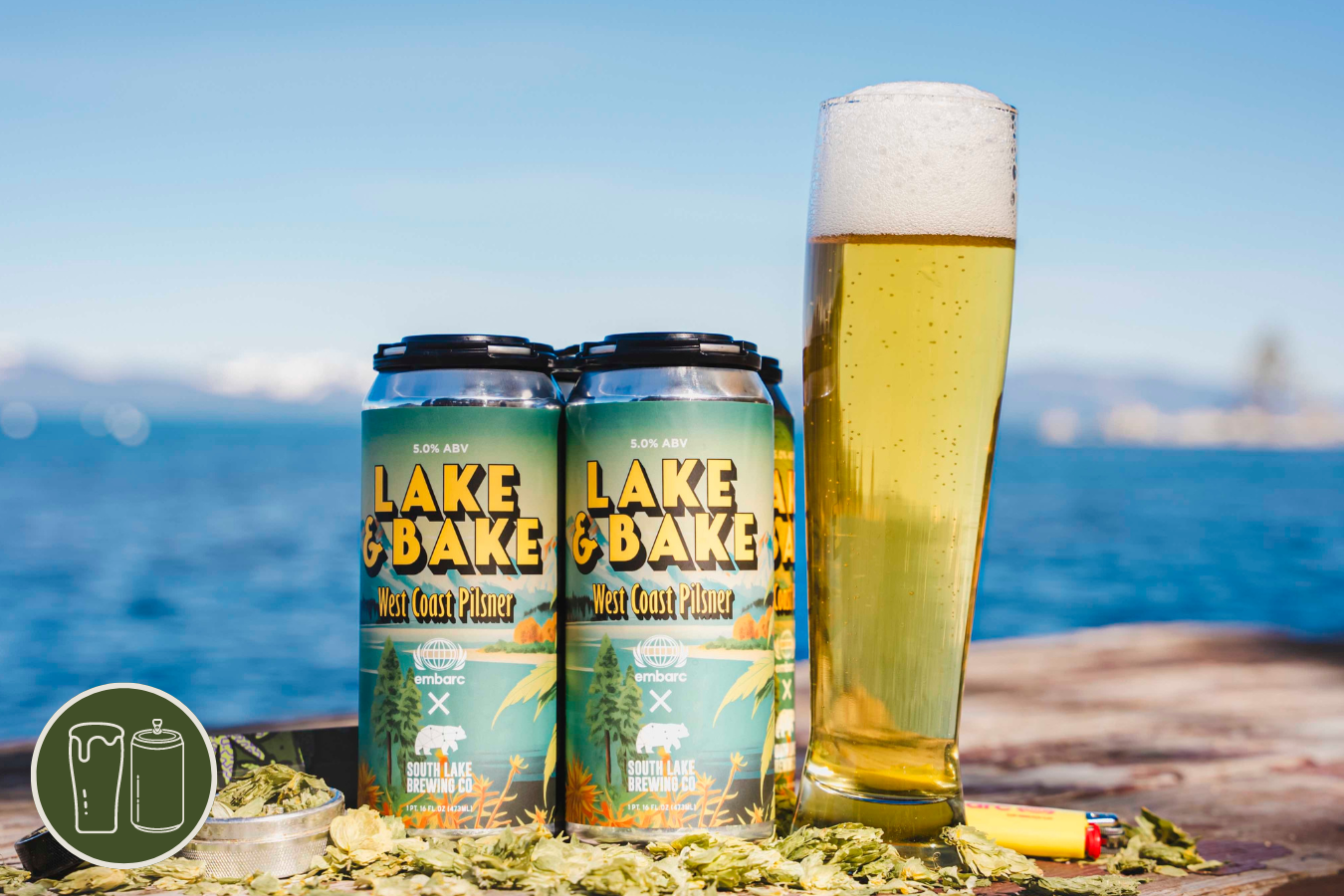 Four pack and pint of Lake & Bake Pilsner surrounded by hops with Lake Tahoe in the background.