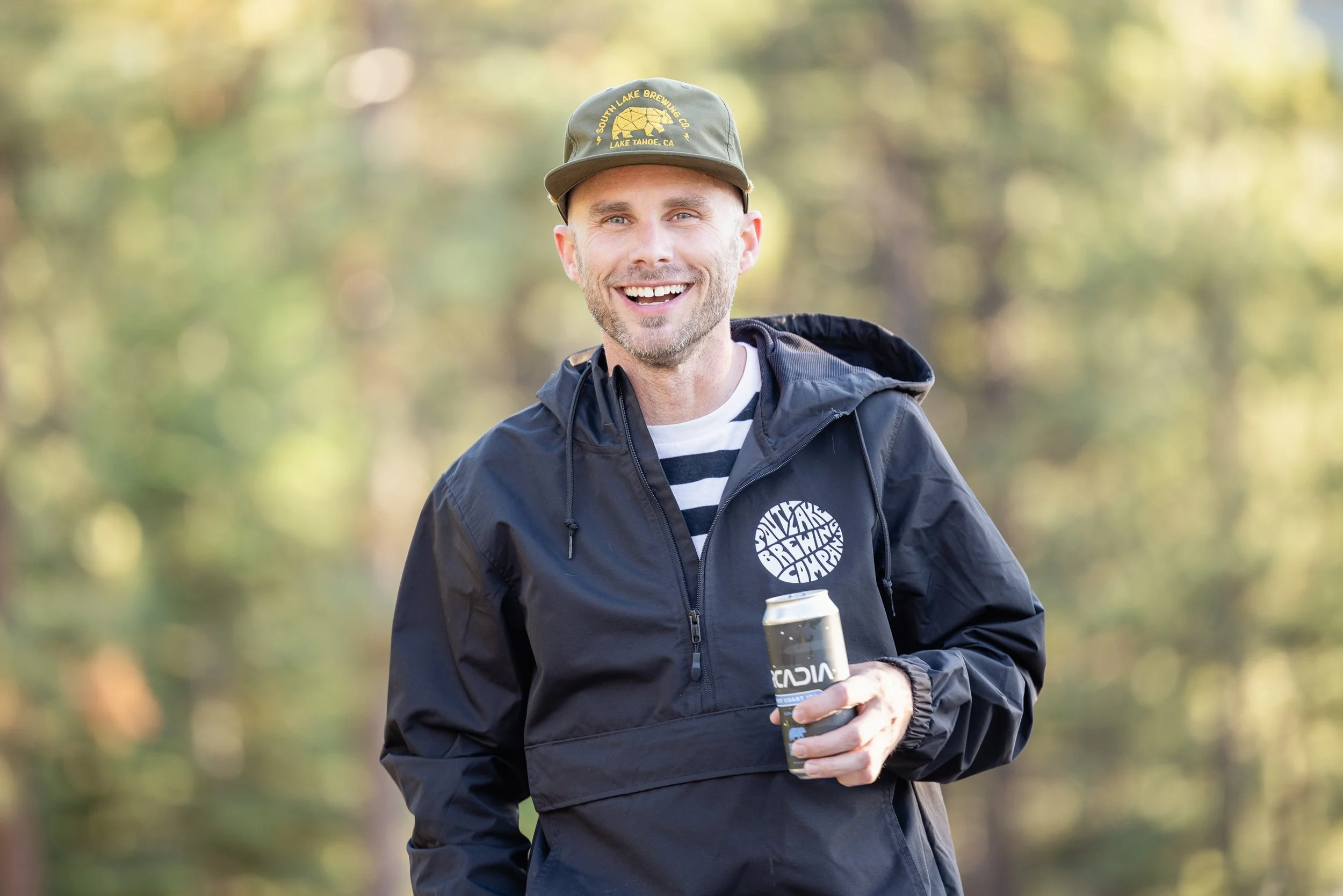Nicholas Wilson, Sales rep for South Lake Brewing Company, smiling and holding a can of beer.
