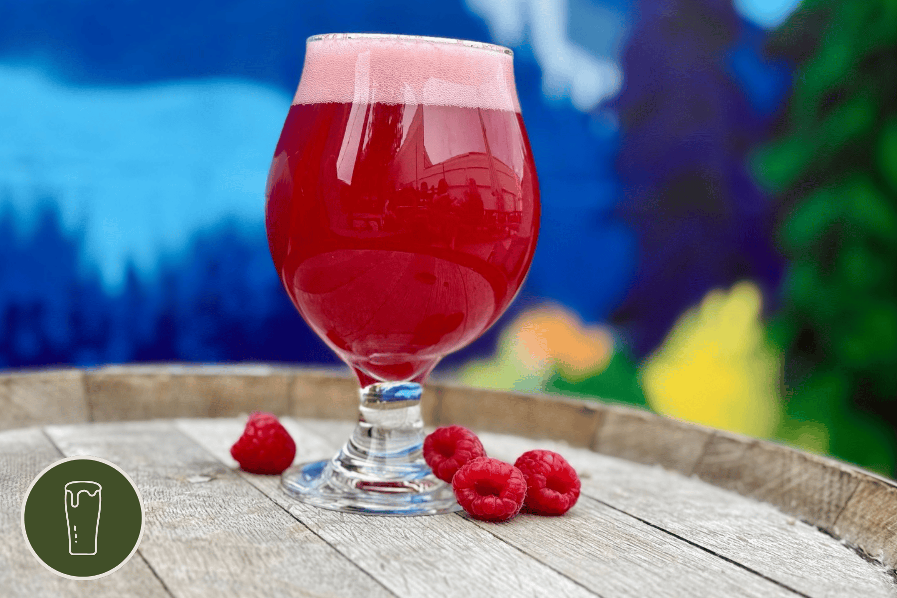 Tulip of Pie Shop sour on a wooden barrel with loose raspberries around it