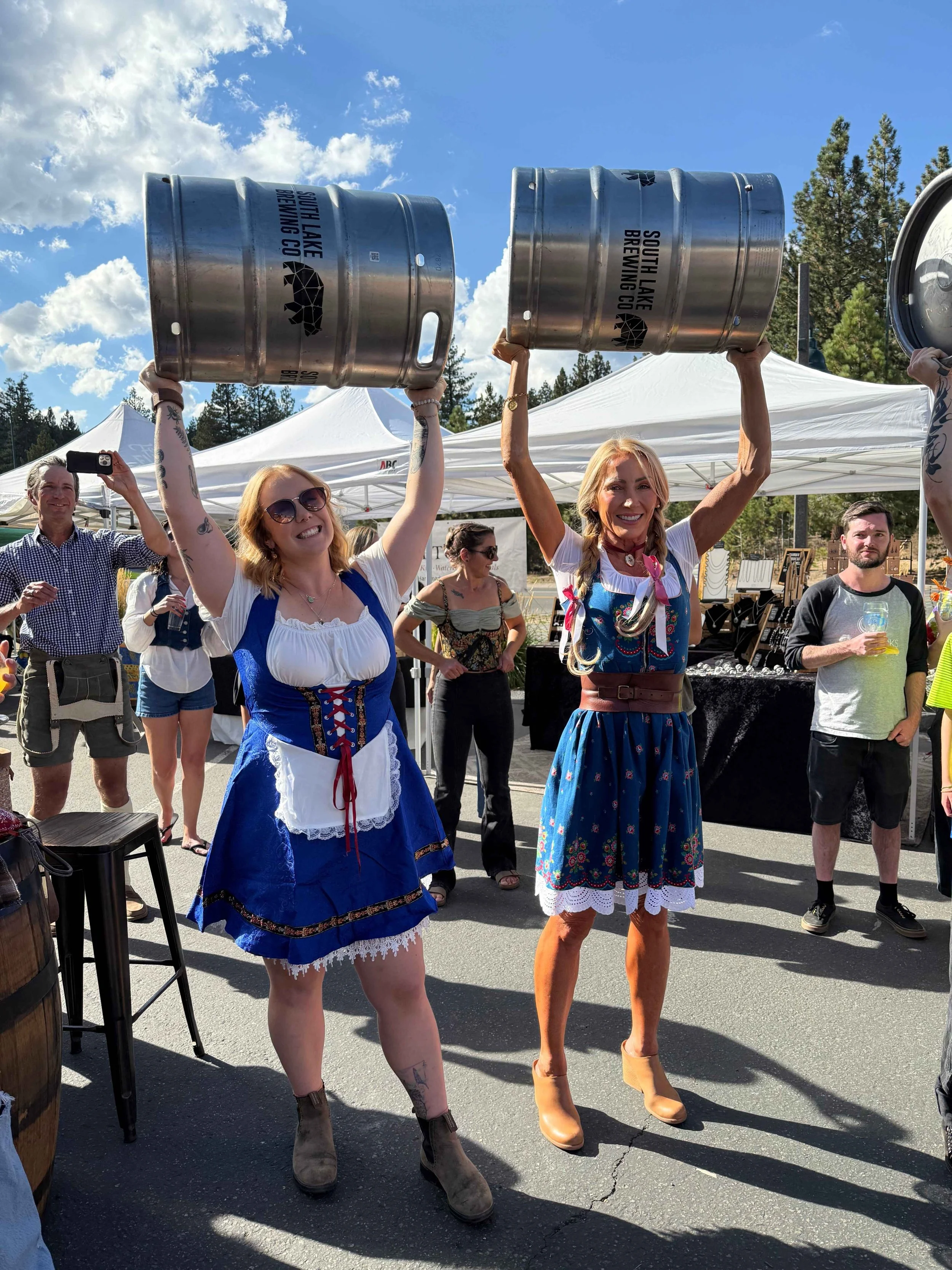 2 women hold kegs of beer