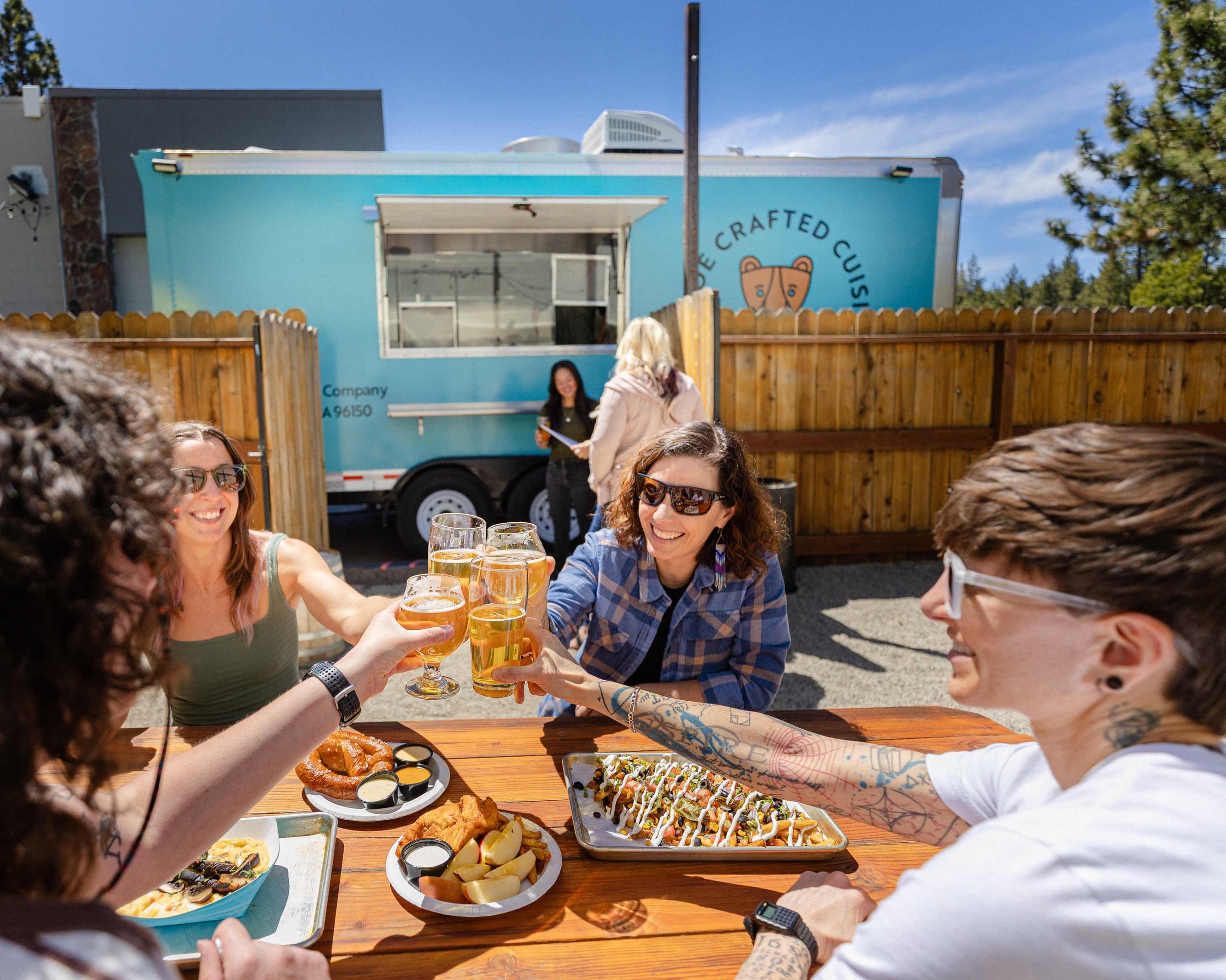 Four people cheers with beers with lunch and dinner from the South Lake Brewing Co. Food Truck