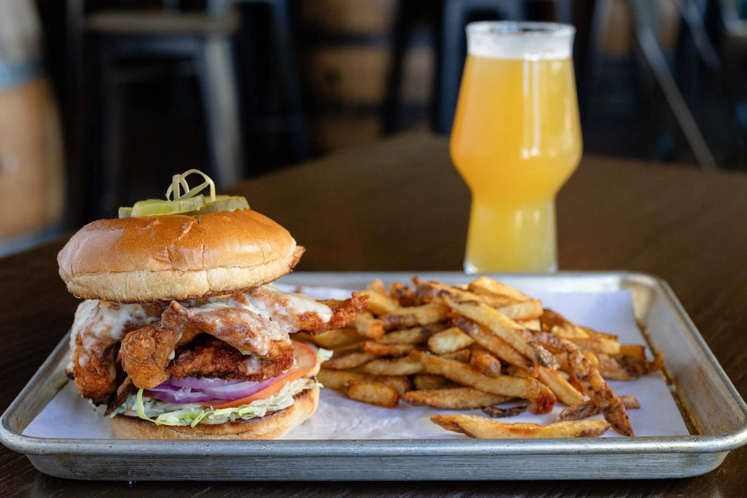 Chicken tender sandwich, fries, and beer