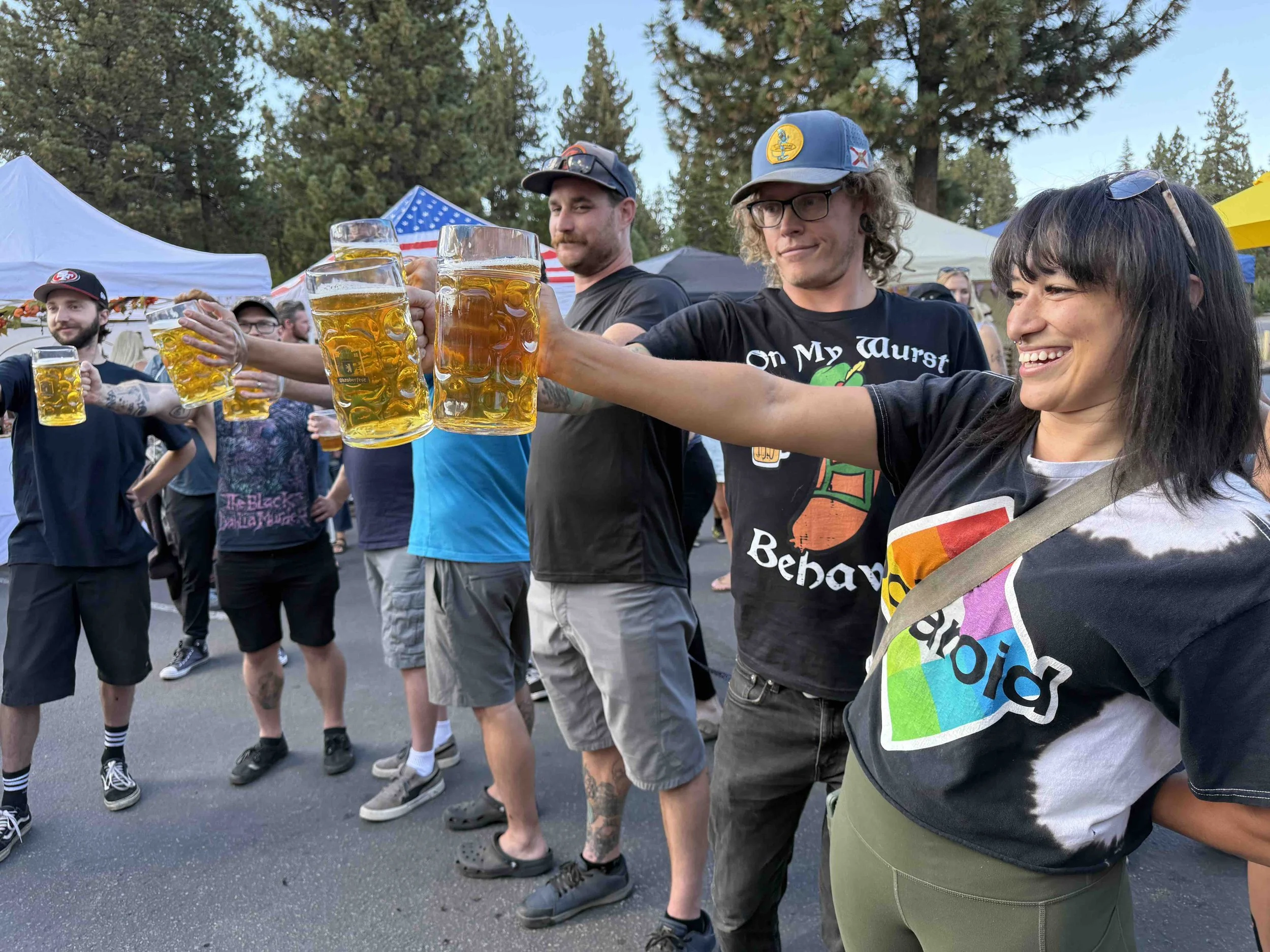 Group of people hold steins with beer