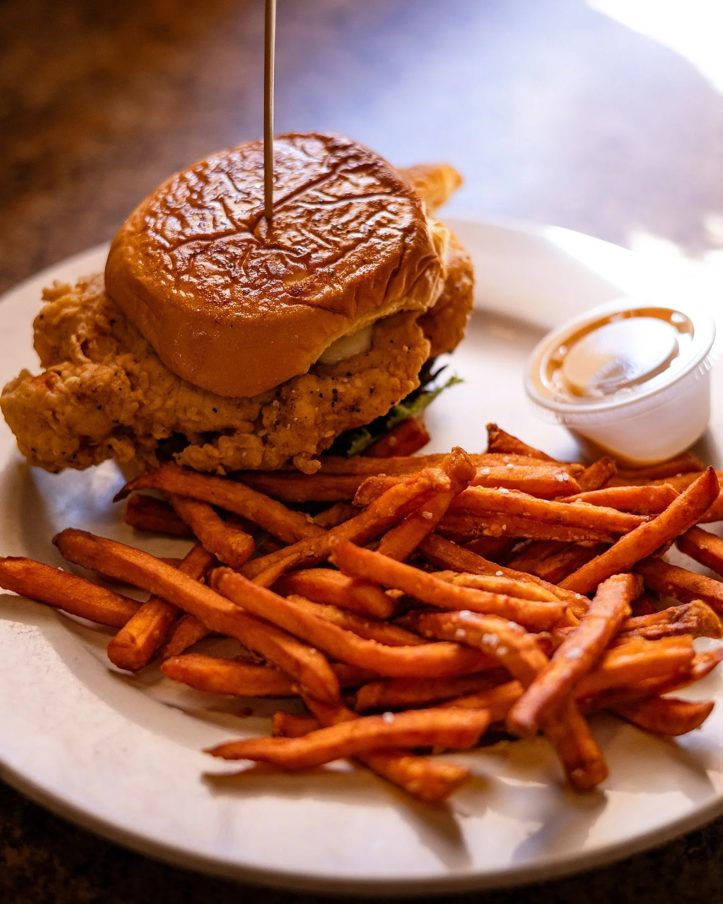 Messy in the best way 🔥🍗

Our Buffalo Chicken Sammy brings the heat with crispy chicken tossed in bold buffalo sauce, stacked just right and served with a side of golden sweet potato fries. Crunchy, spicy, and wildly satisfying, this is the kind of