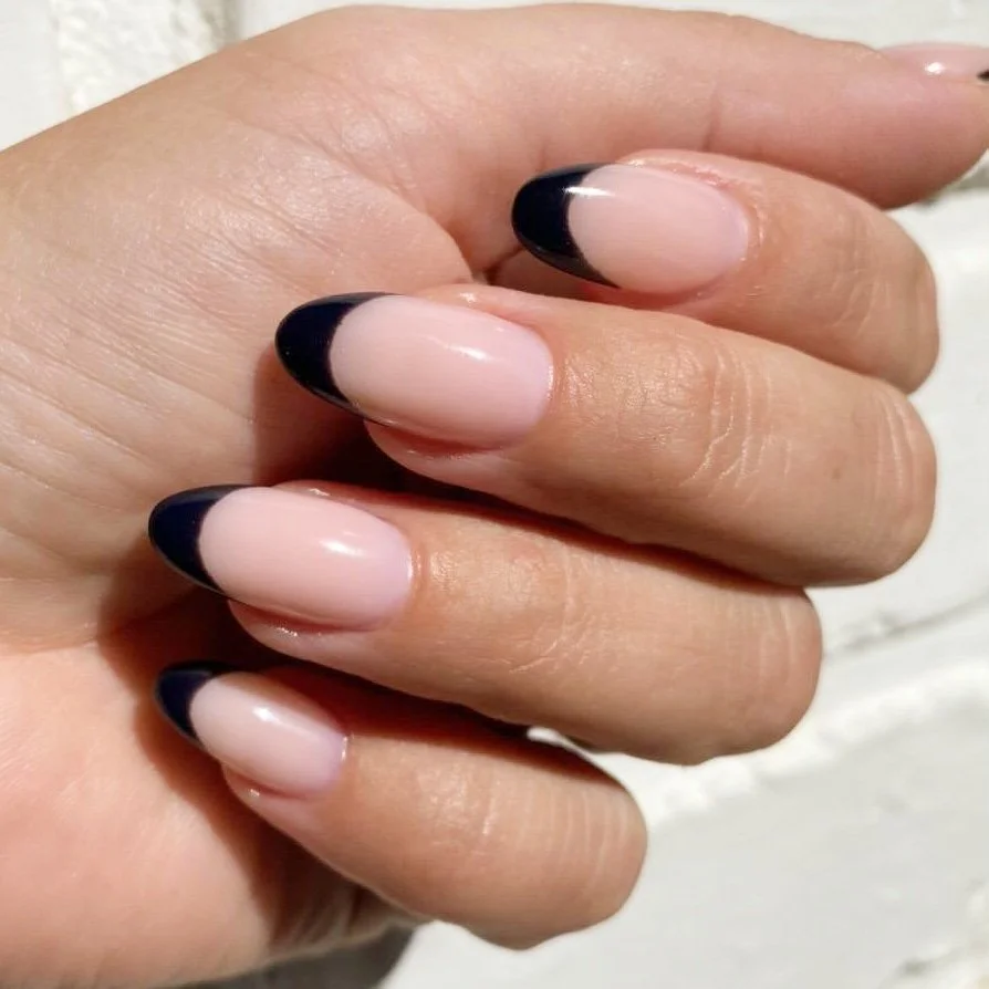 Nålekunst med fransk manicure og sorte spidser på neglene.