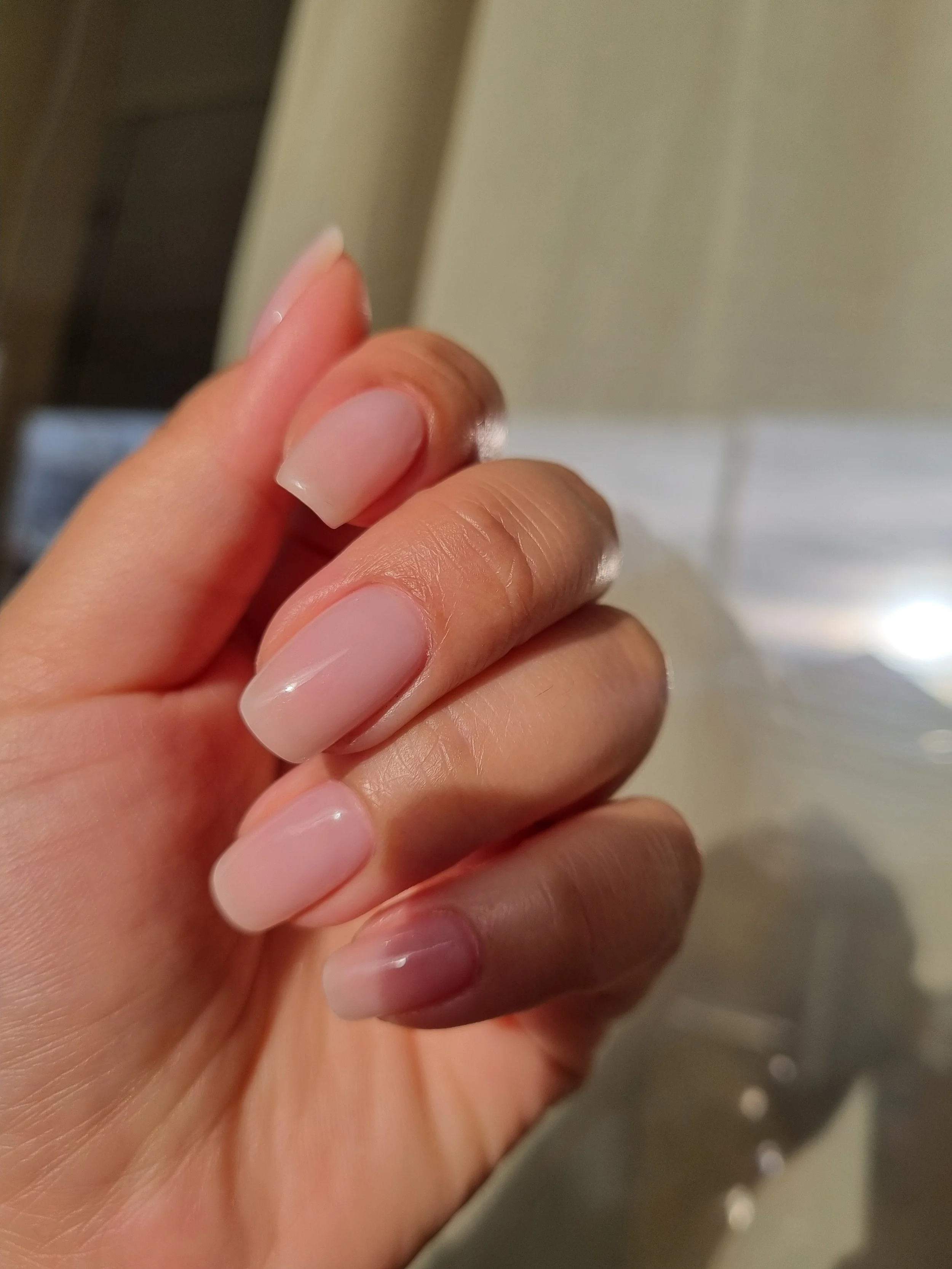 Et nærbillede af en hånd med naturfarvede, velplejede negle.
