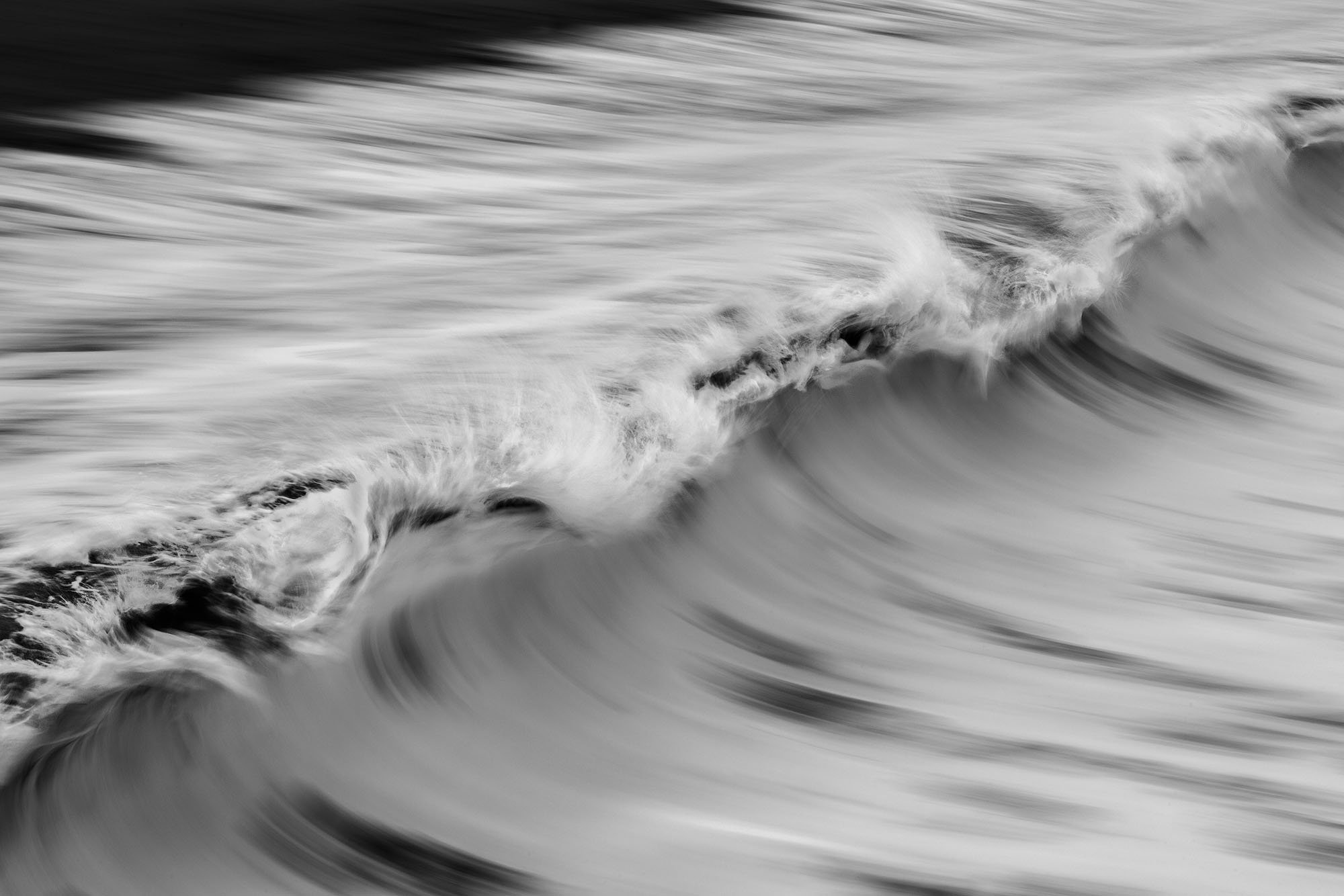 Black and white photograph of ocean waves in motion.