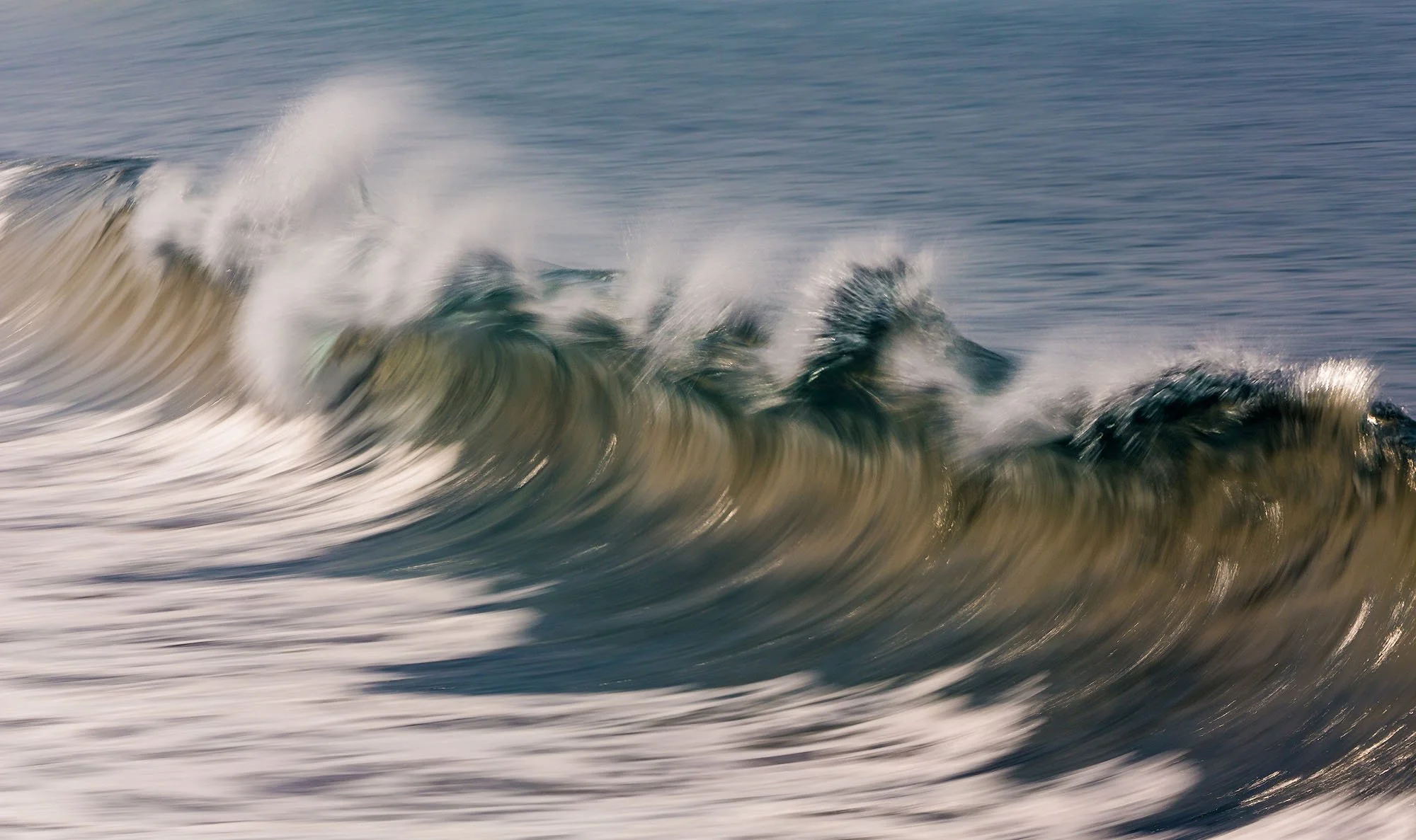 Waves crashing in the ocean with white foam and spray.