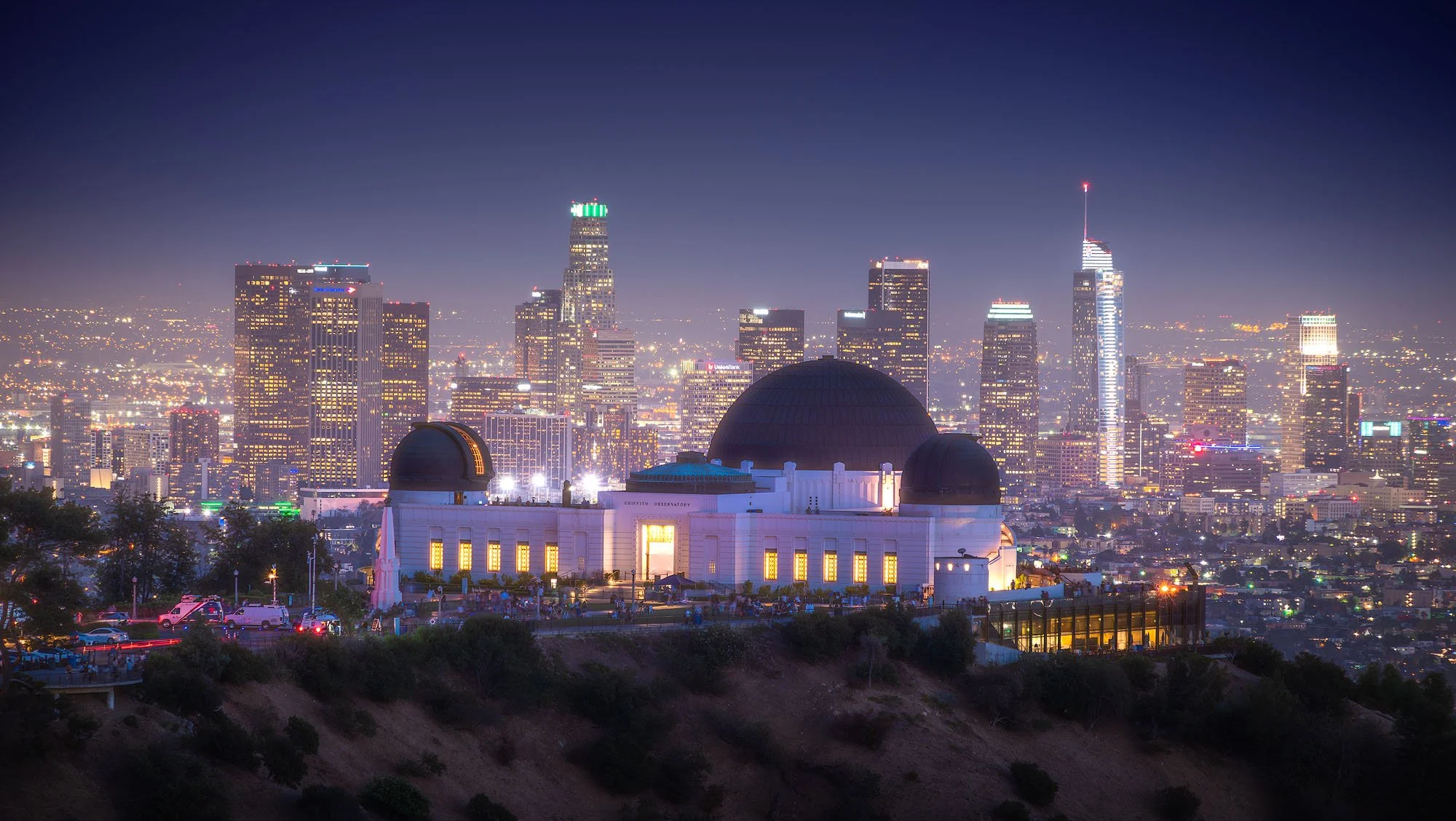 Night view of the Griffith Observatory with Los Angeles skyline in the background.