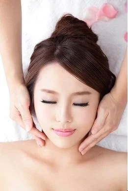 Woman undertaking facial treatments, including gold face mask
