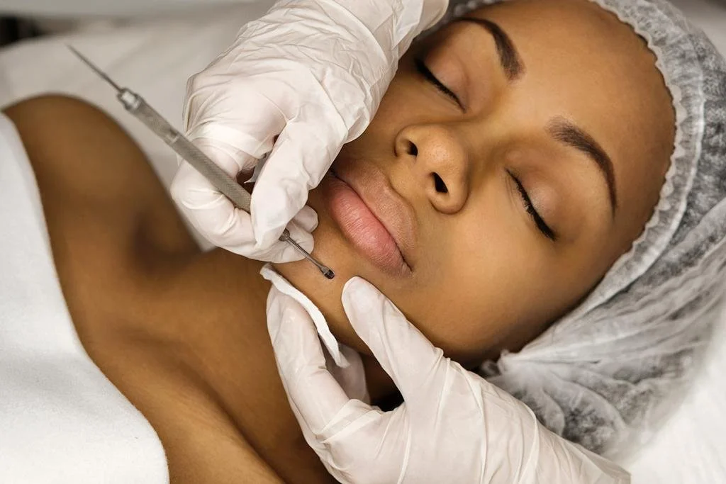 Woman receiving facial treatment administered with a brush