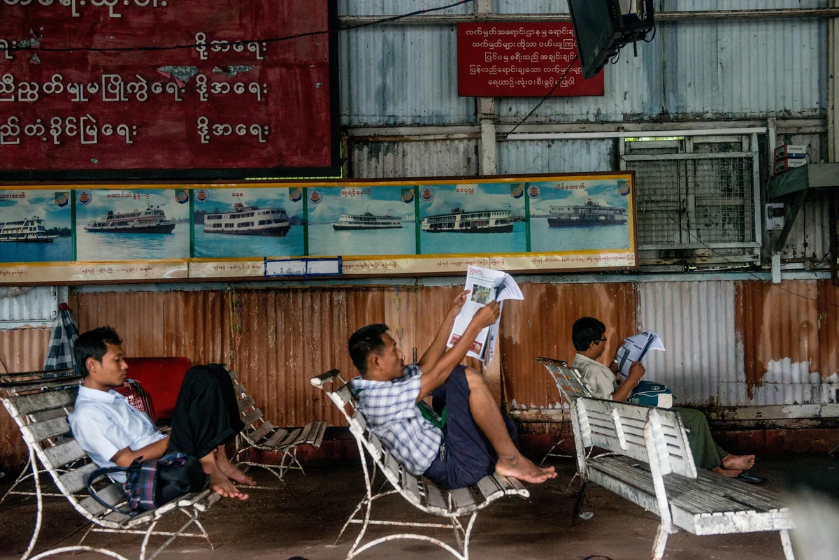  Commuters wait for the ticket office to open up at the ferry station along the jetty in downtown Yangon. 