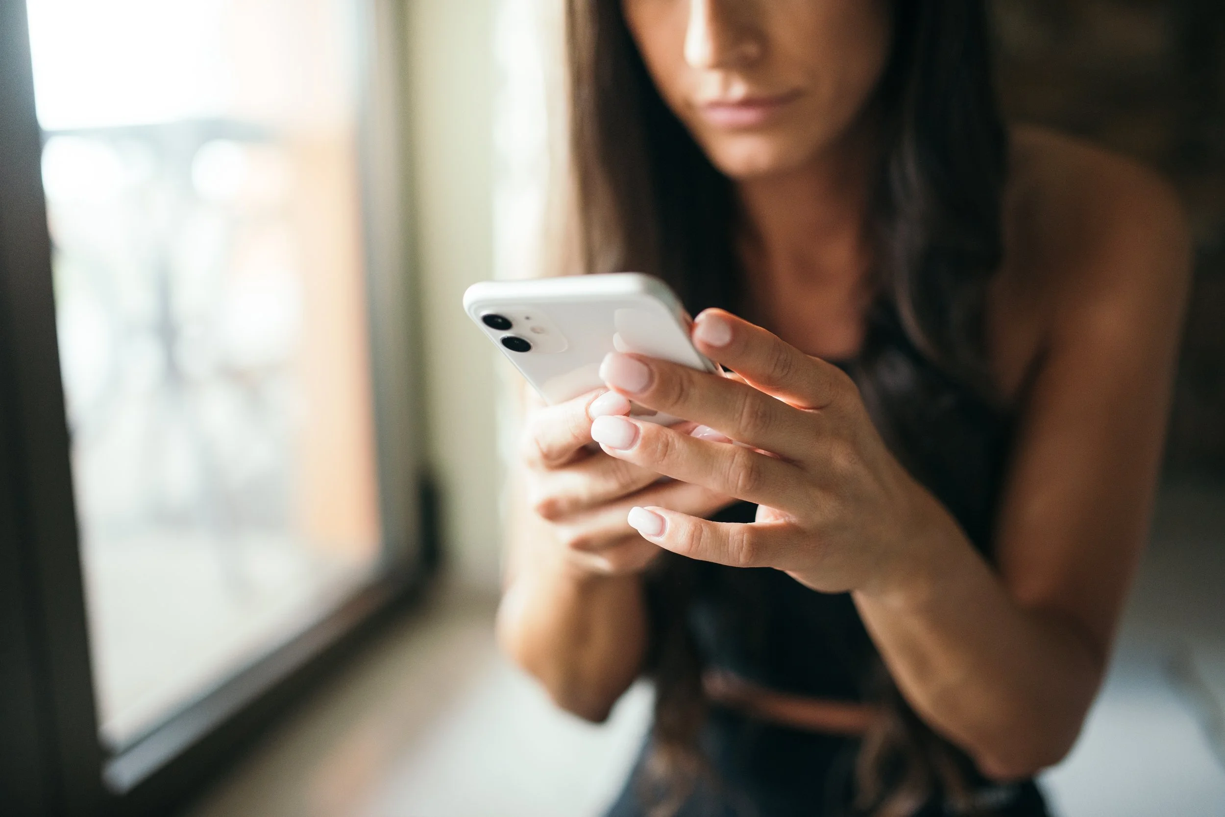 A woman checks her smartphone.