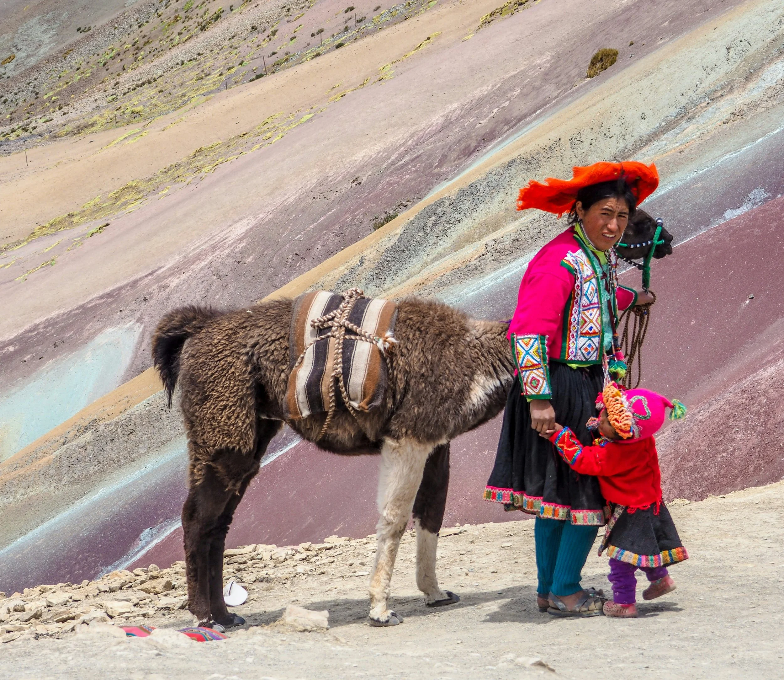 Many Indigenous people make money at Rainbow Mountain by letting tourists pose with their llamas for a photo. Ioana Mohanu. Unsplash.
