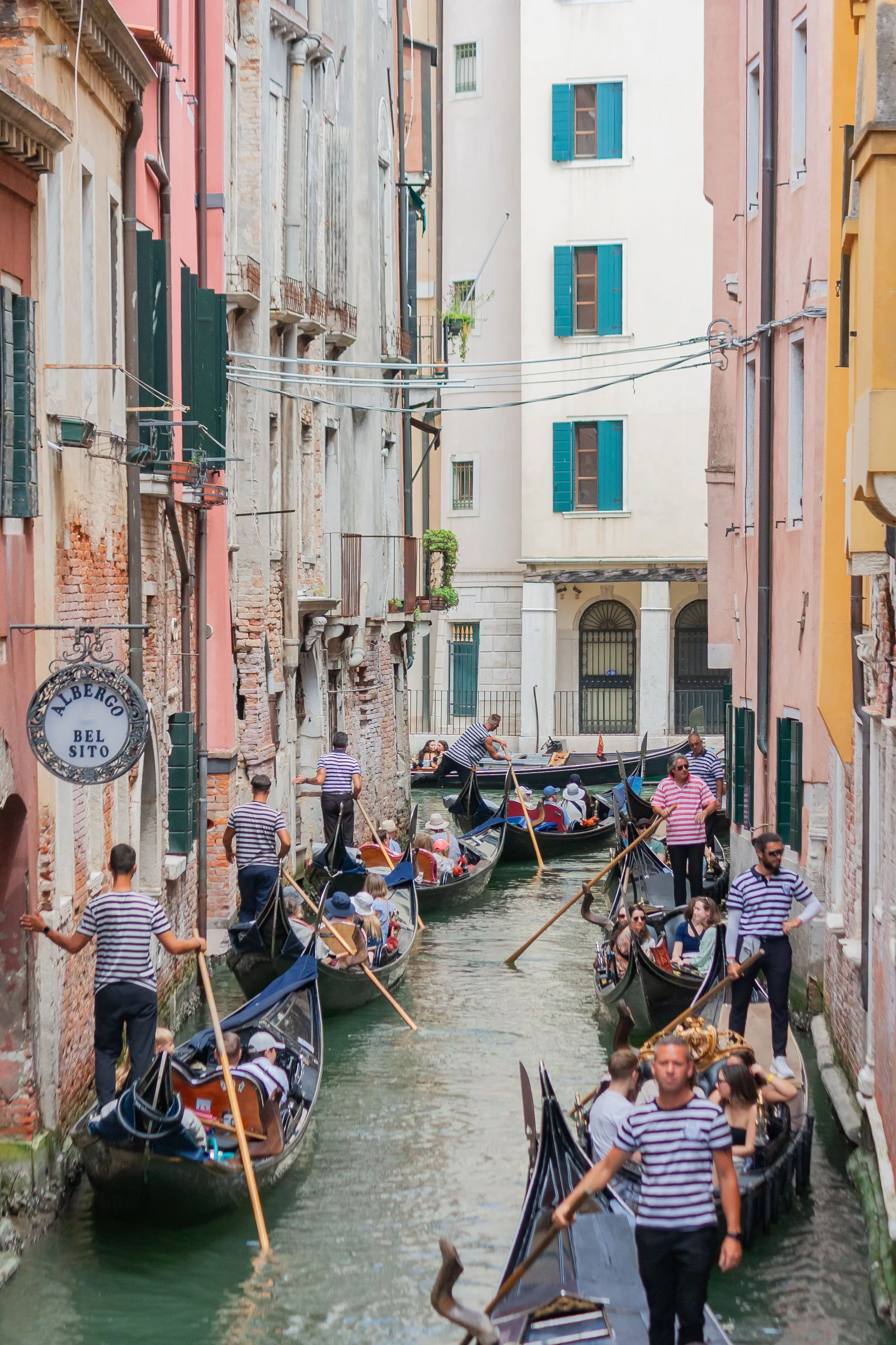A Venice canal filled with gondolas for tourists.
