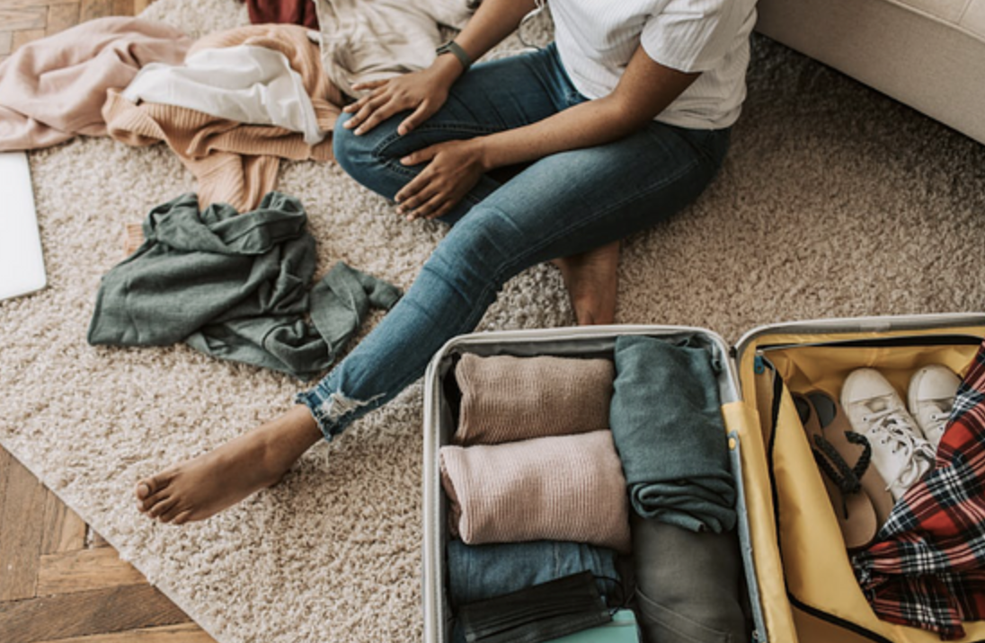 Woman packing clothes into a suitcase.