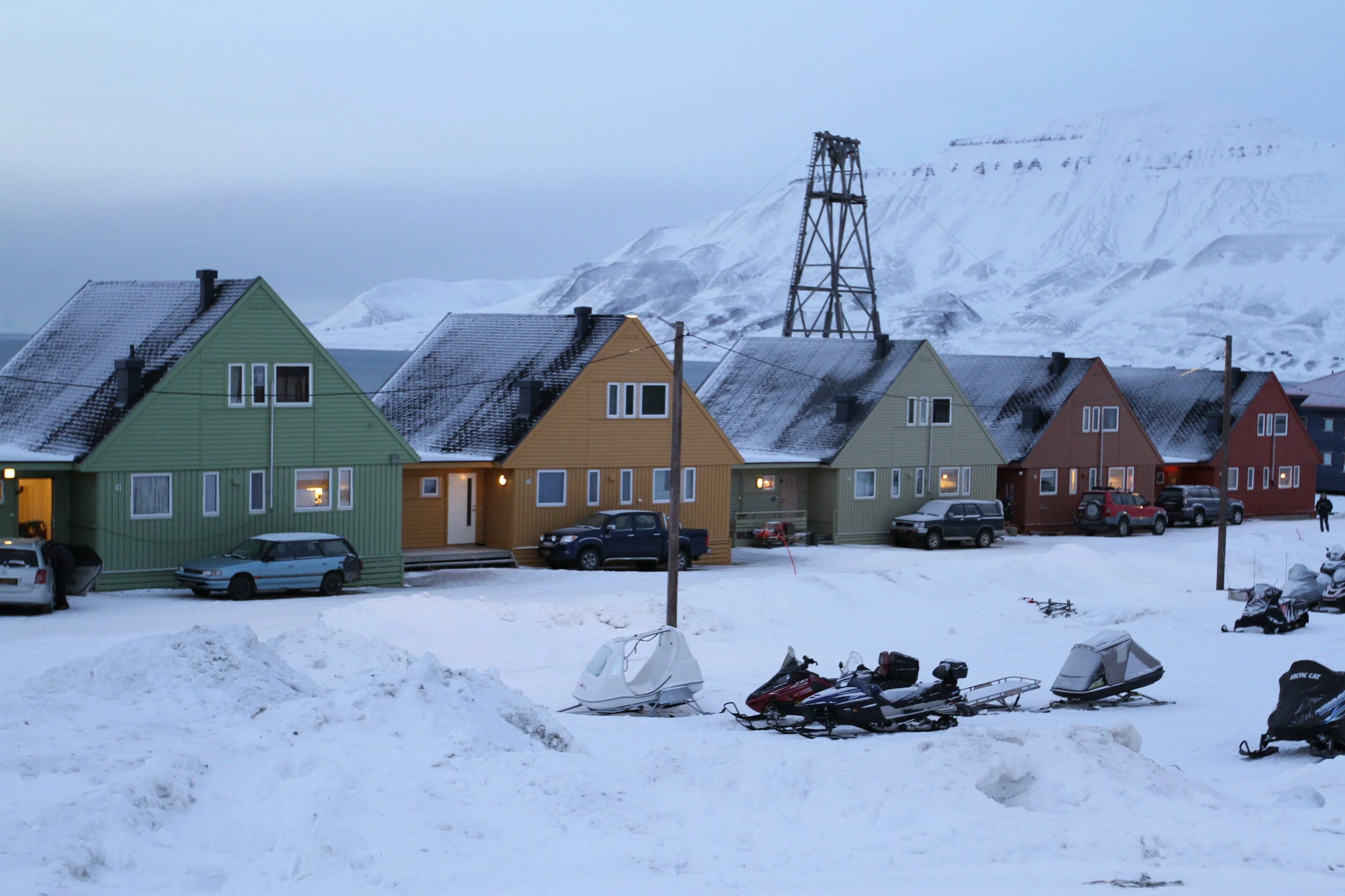 Different colored houses surrounded by snow in Svalbard, Norway.