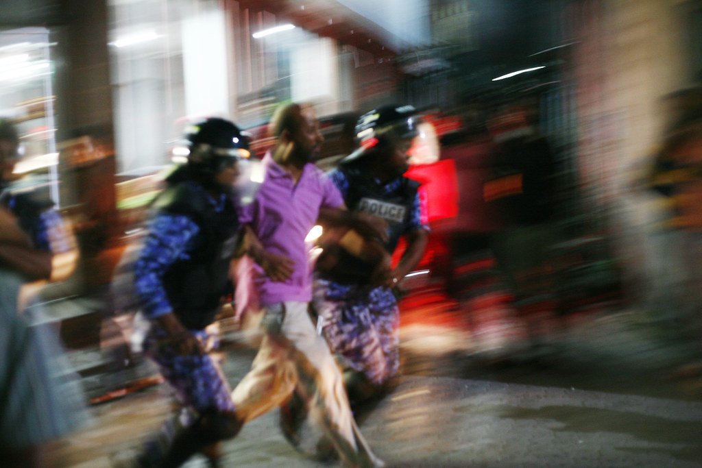 An individual being dragged away by police during protests. Dying Regime. CC by 2.0.