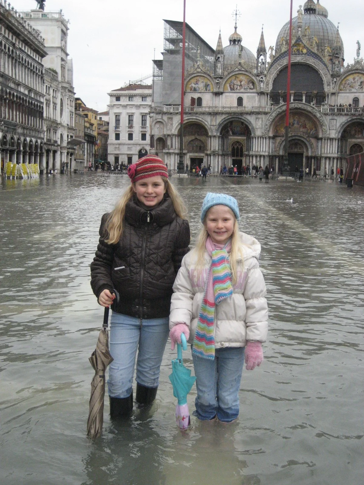 Two sisters walking through the acqua alta (high water) in Saint Mark’s Square.