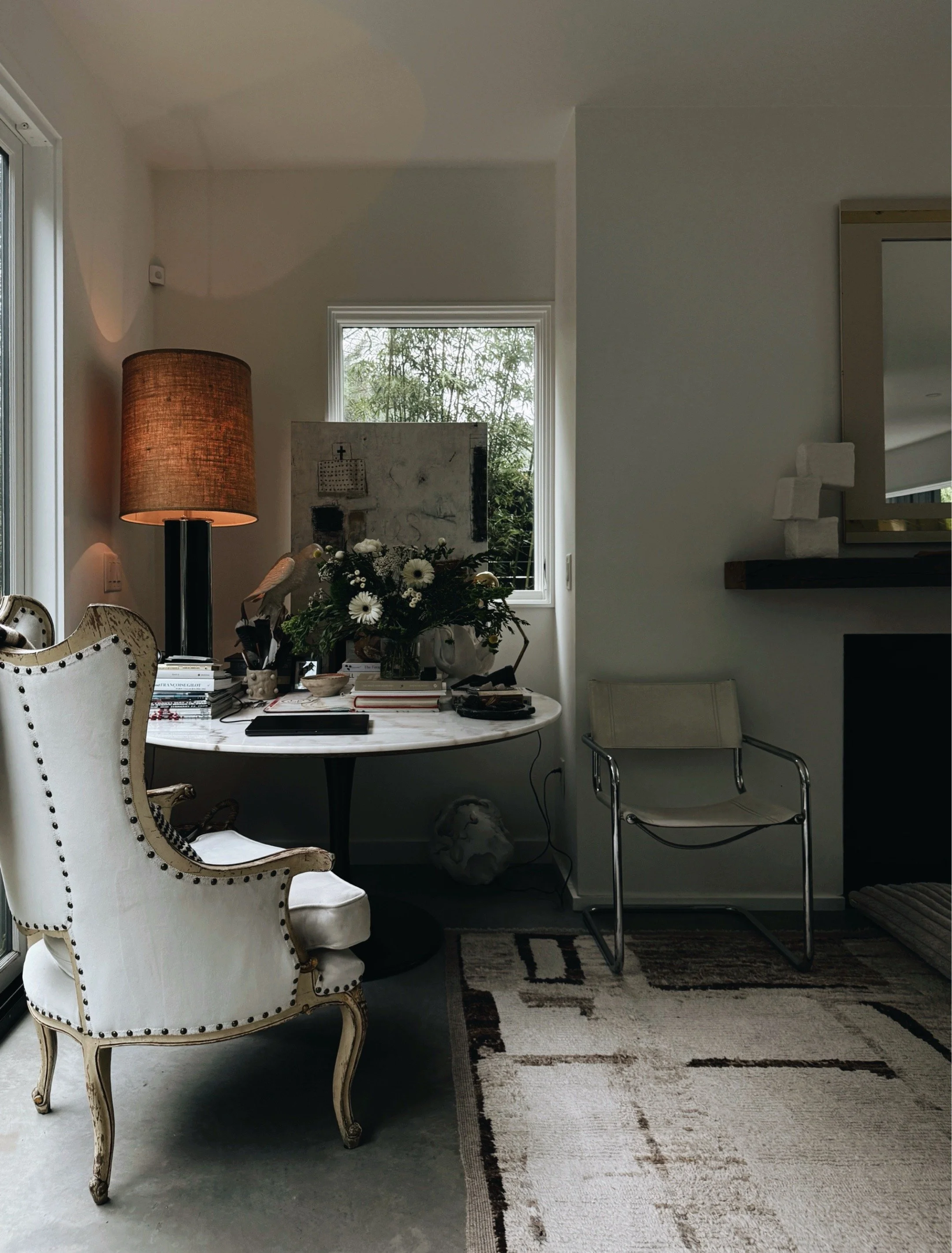 Black and white living room with modern furniture, layered artwork, and natural textures.