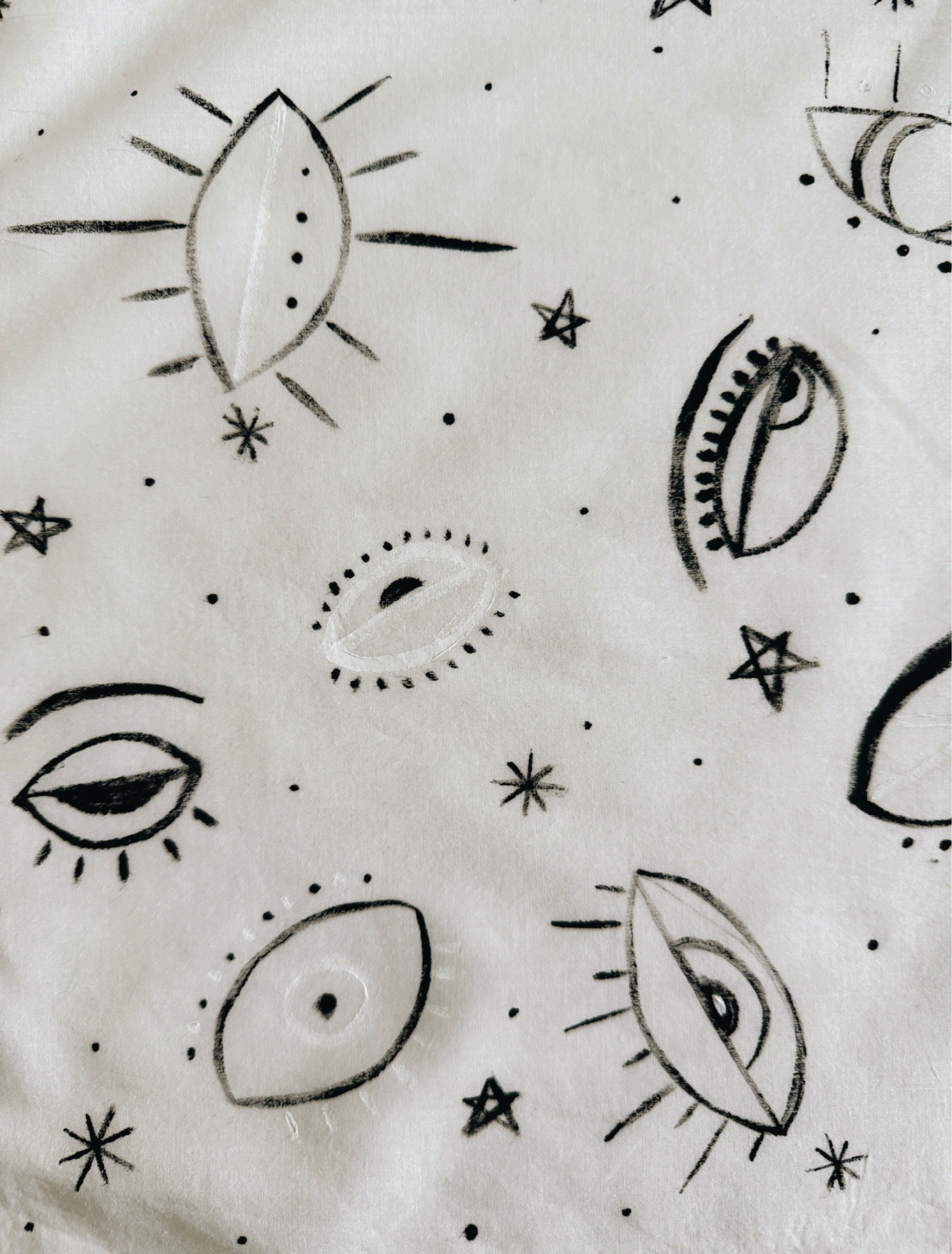 Black and white scarf handkerchief featuring hand drawn eyes, stars, and celestial inspired symbols. by artist and psychotherapist Michel Van Devender