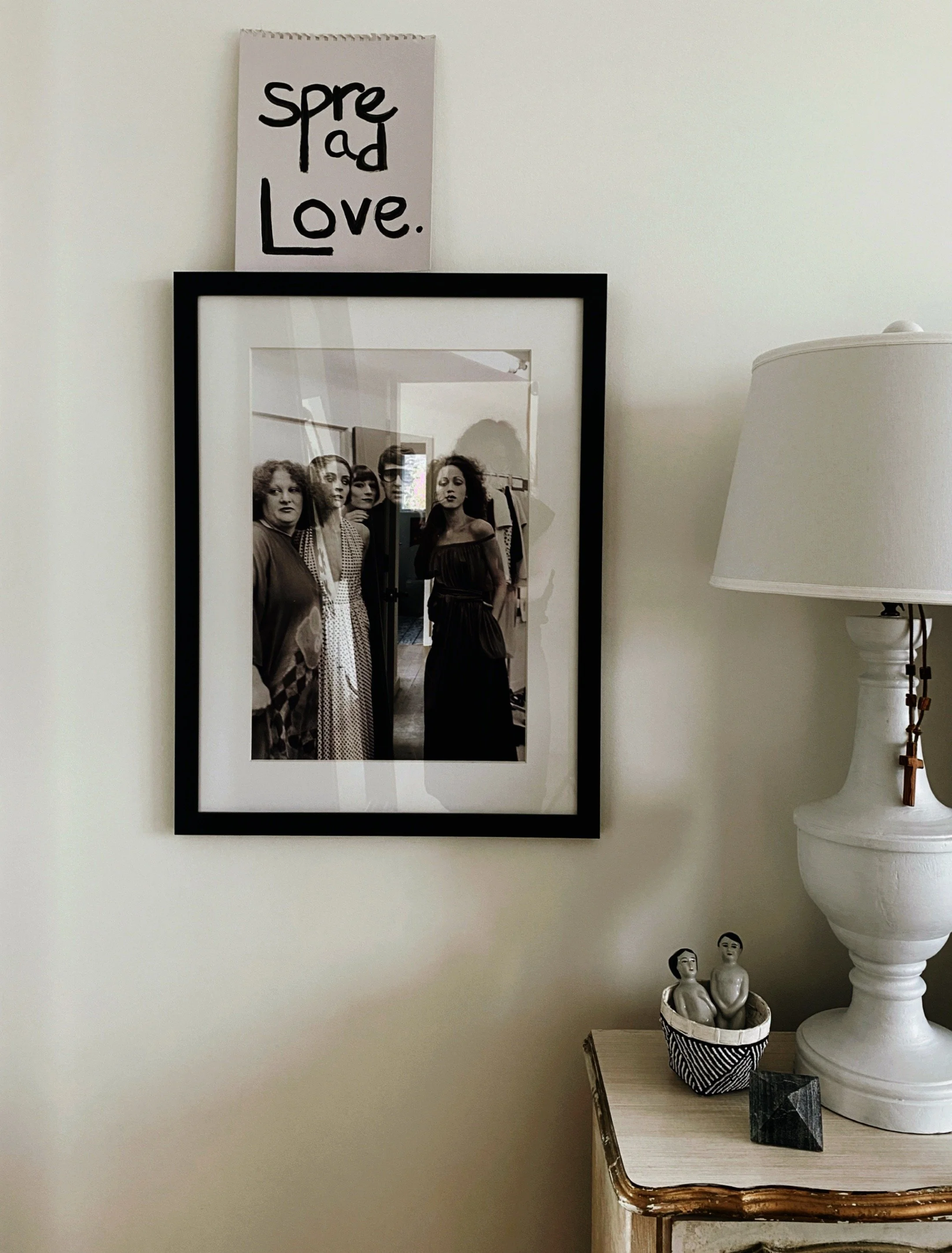 photo of beside table, lamp and photograph art on wall with spread love from the home of artist and designer michel van devender