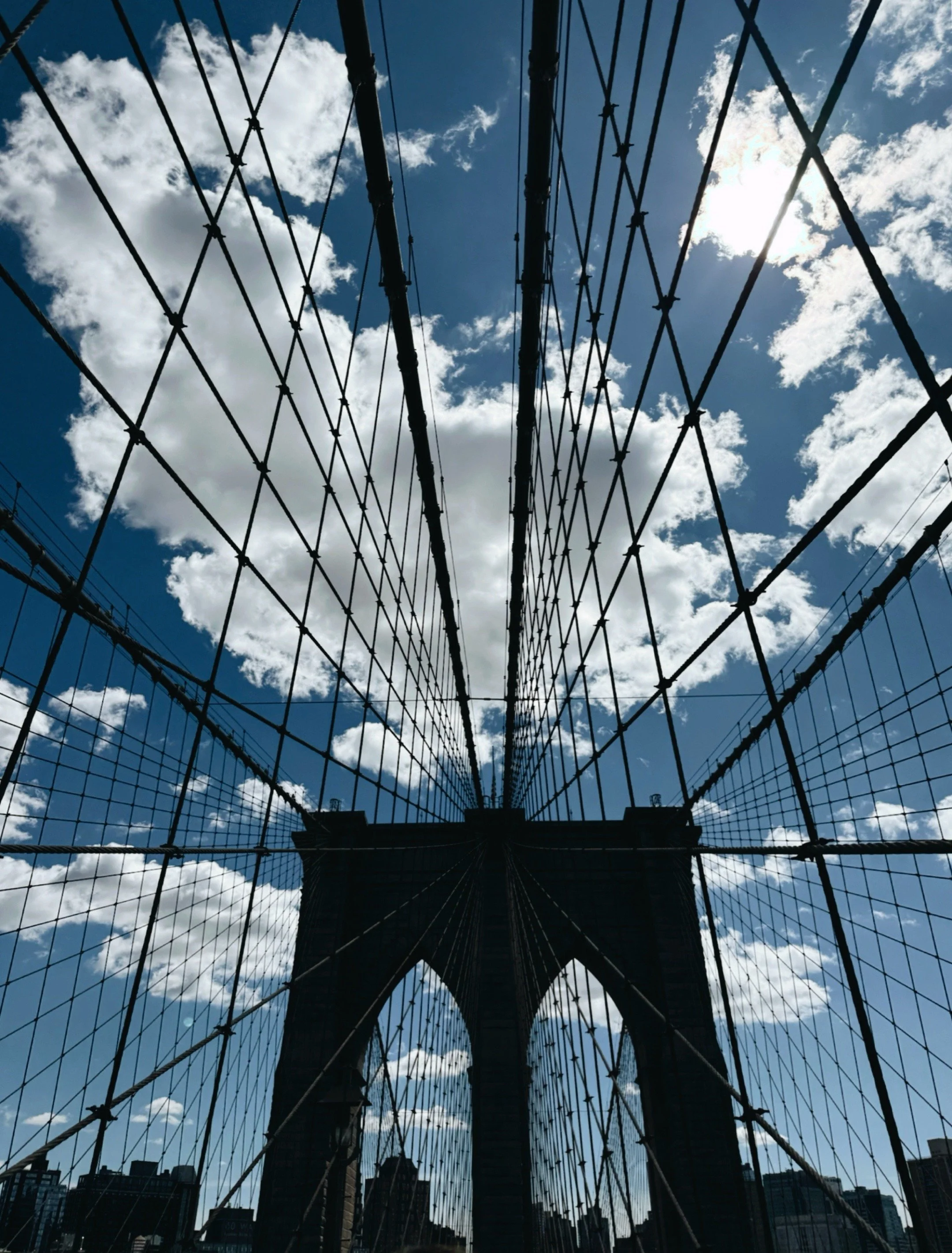 View looking up through the cables and structure of the Brooklyn Bridge in New York City.