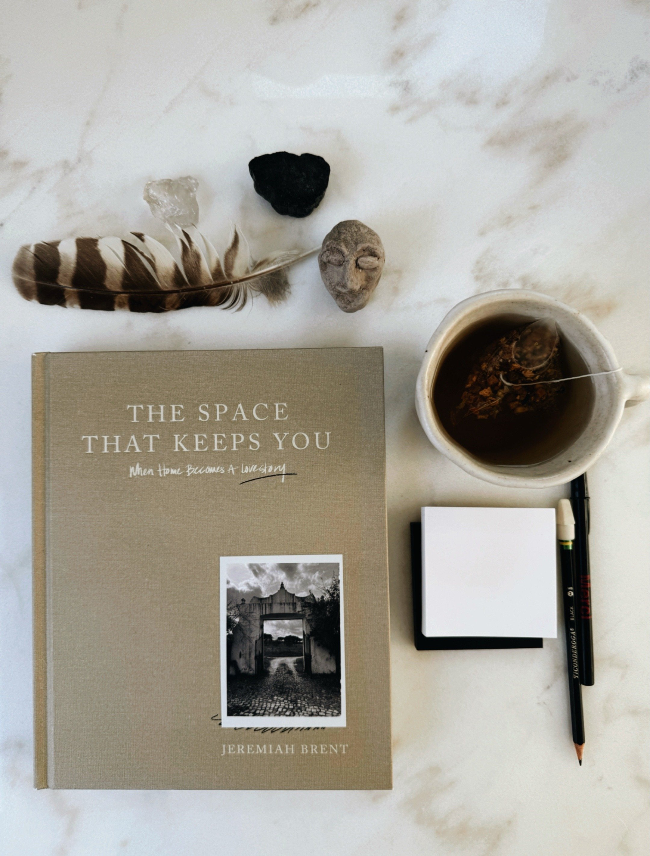 The Space That Keeps You by Jeremiah Brent interior design book on studio table.