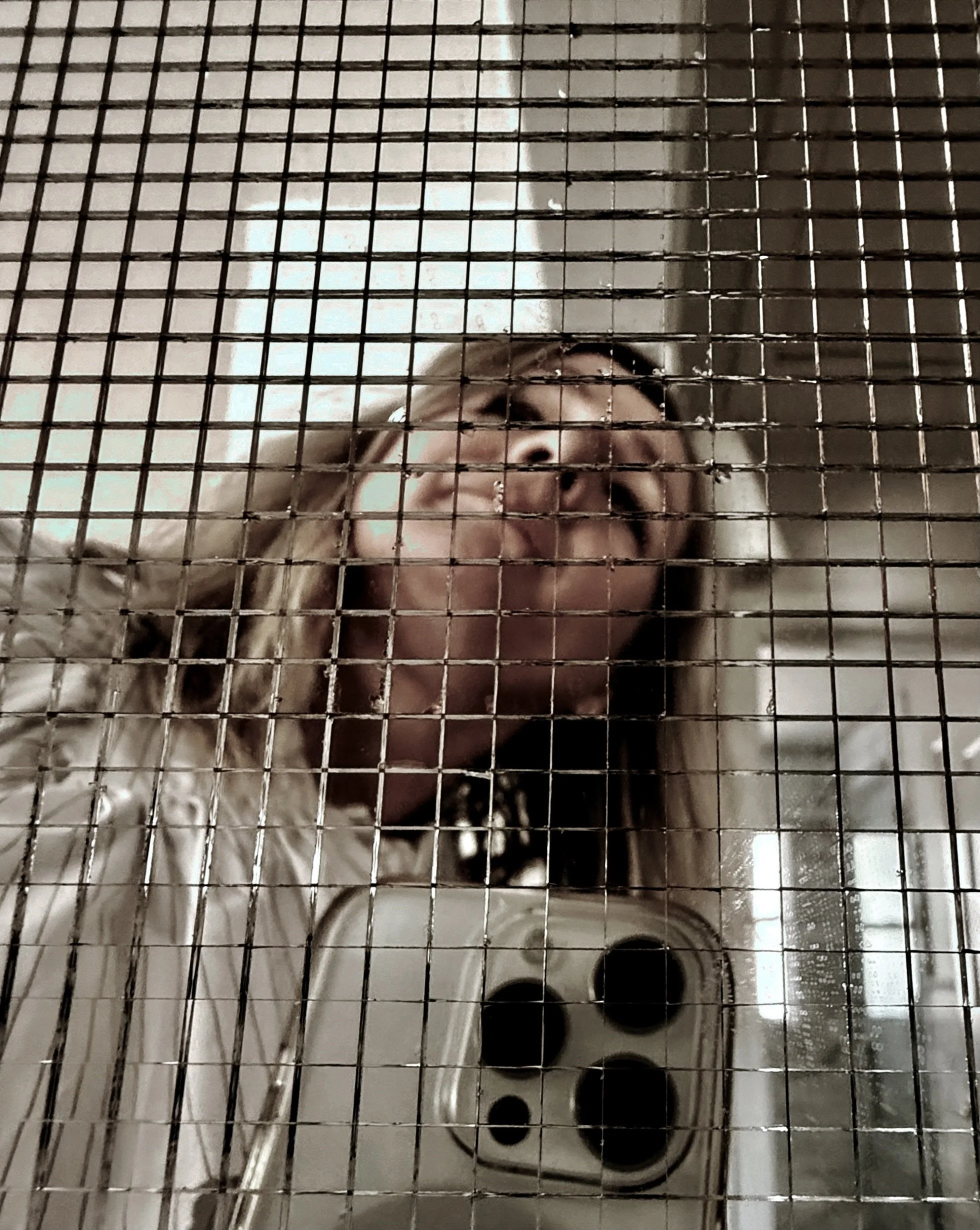 A creative selfie shot of artist Michel Van Devender with small square mirror pieces on a doorway threshold.