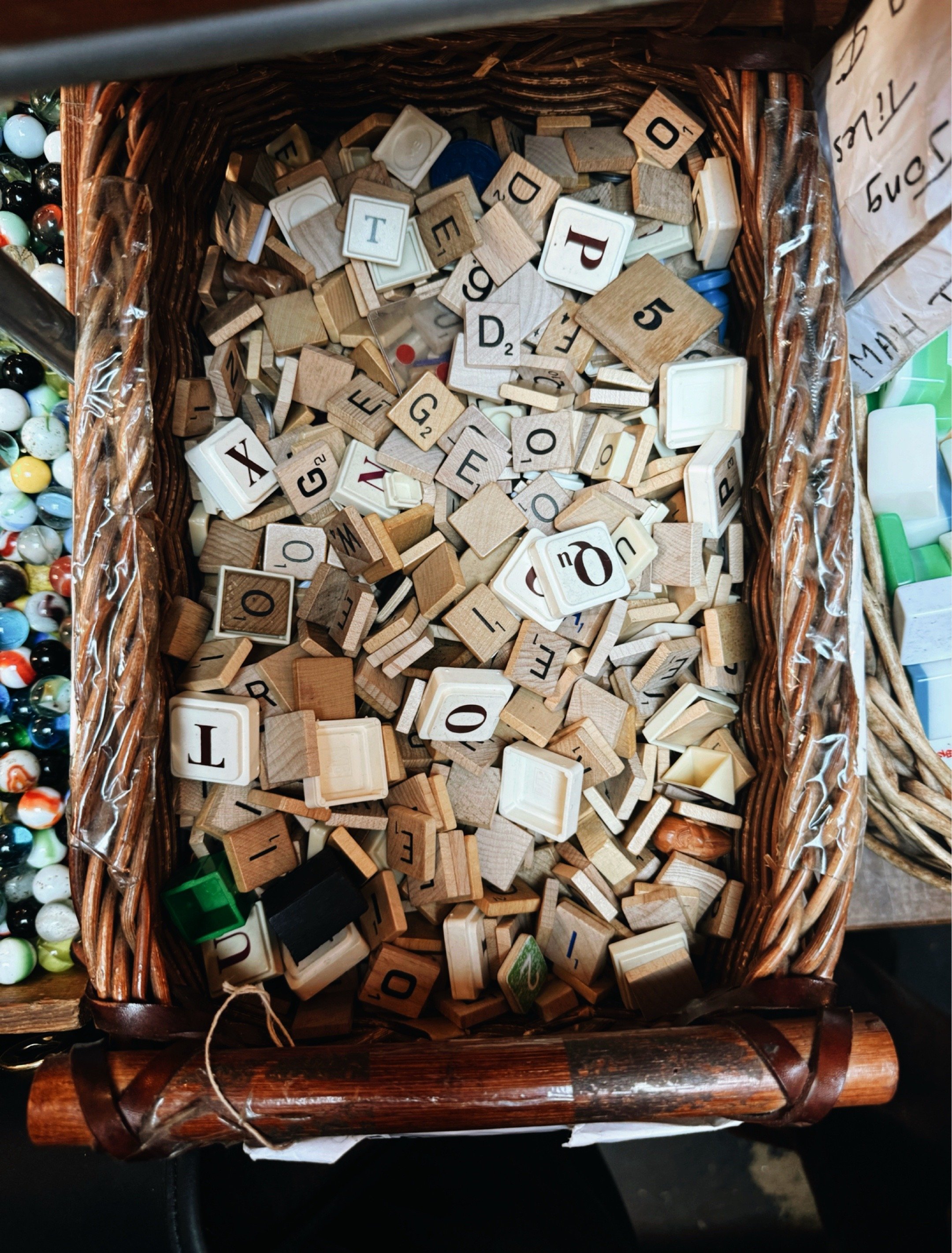 Collection of vintage letter tiles arranged in a wooden tray at Mother of Junk in Brooklyn, NY.