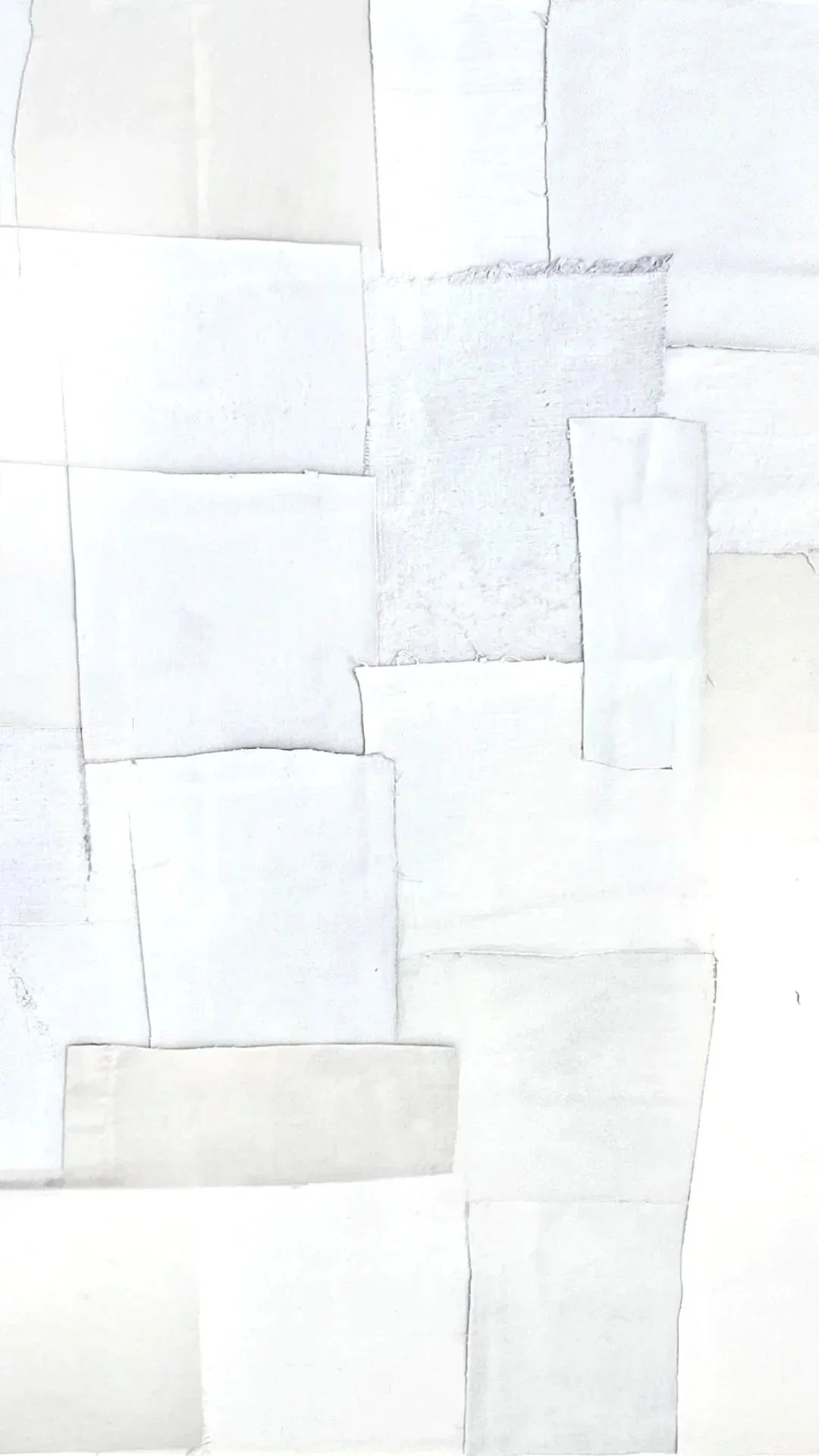 Collage of white textured and plain papers arranged in overlapping layers.