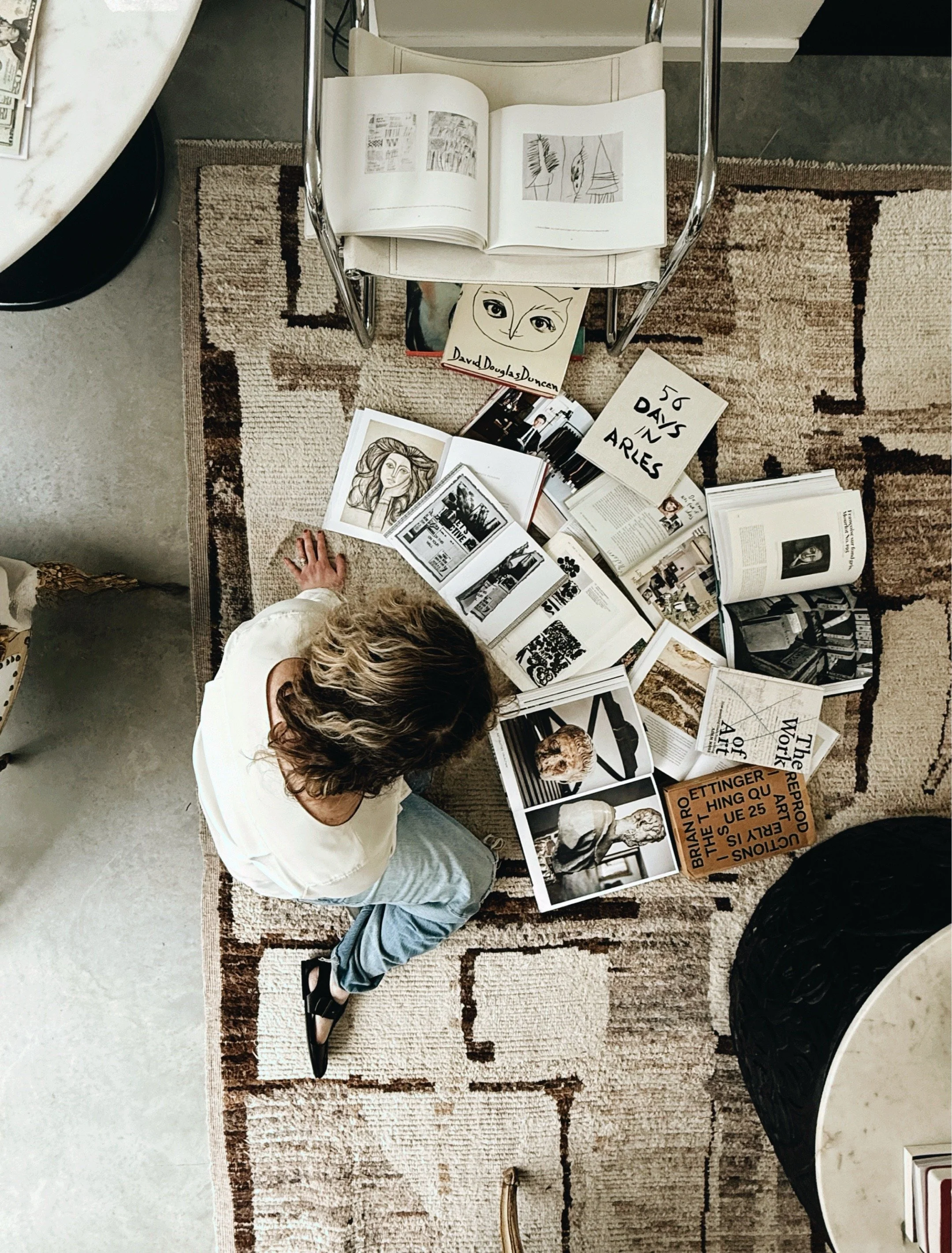 art and design books spread across floor for creative inspiration.