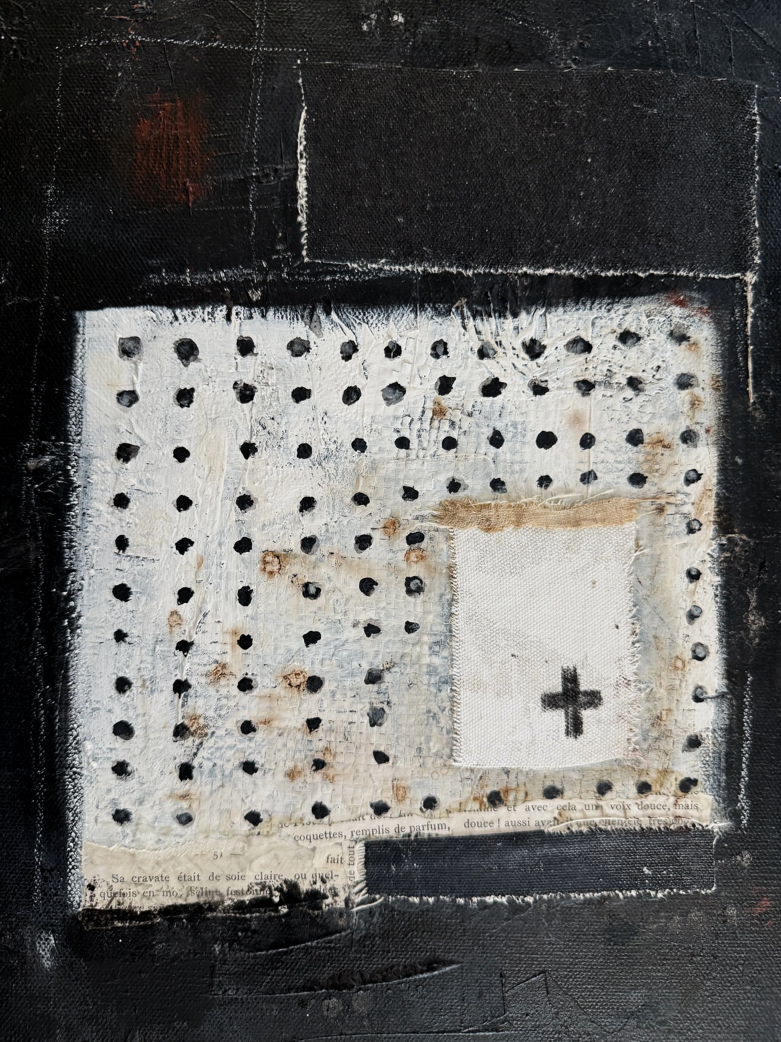 Detail of Michel Van Devender's abstract painting Saints and Sinners, showing layered black and white paint, textile collage elements, hand-stitched dots and a cross mark on raw canvas with vintage French text