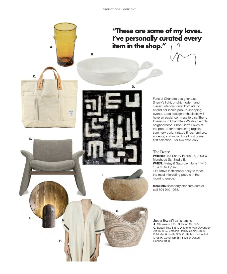 Collection of home decor and accessories, including a tall glass with amber and dark brown gradient (A), white ceramic bowl with two spoons (B), beige fabric tote bag with tan leather handles (C), black and white graphic patterned rug (D), gray cushioned armchair with wooden legs (E), stone mortar and pestle (F), woven basket with handle (G), woman wearing light-colored robe (H), and round decorative wall art with metallic gold and dark brown finish (I).