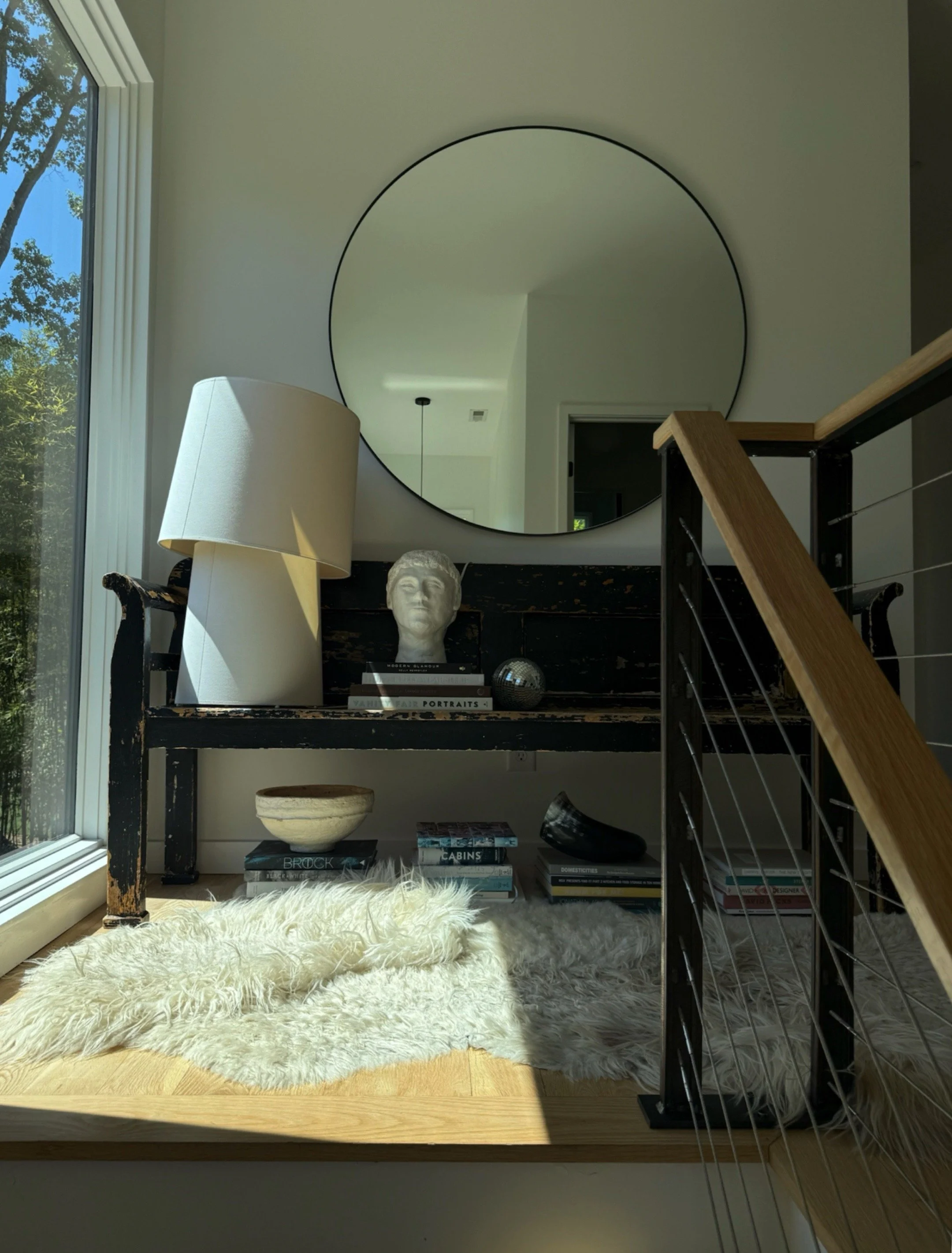 modern contemporary stairs and landing with rustic bench, paper lamp, round mirror and bust from the charlotte nc home of abstract artist michel van devender.