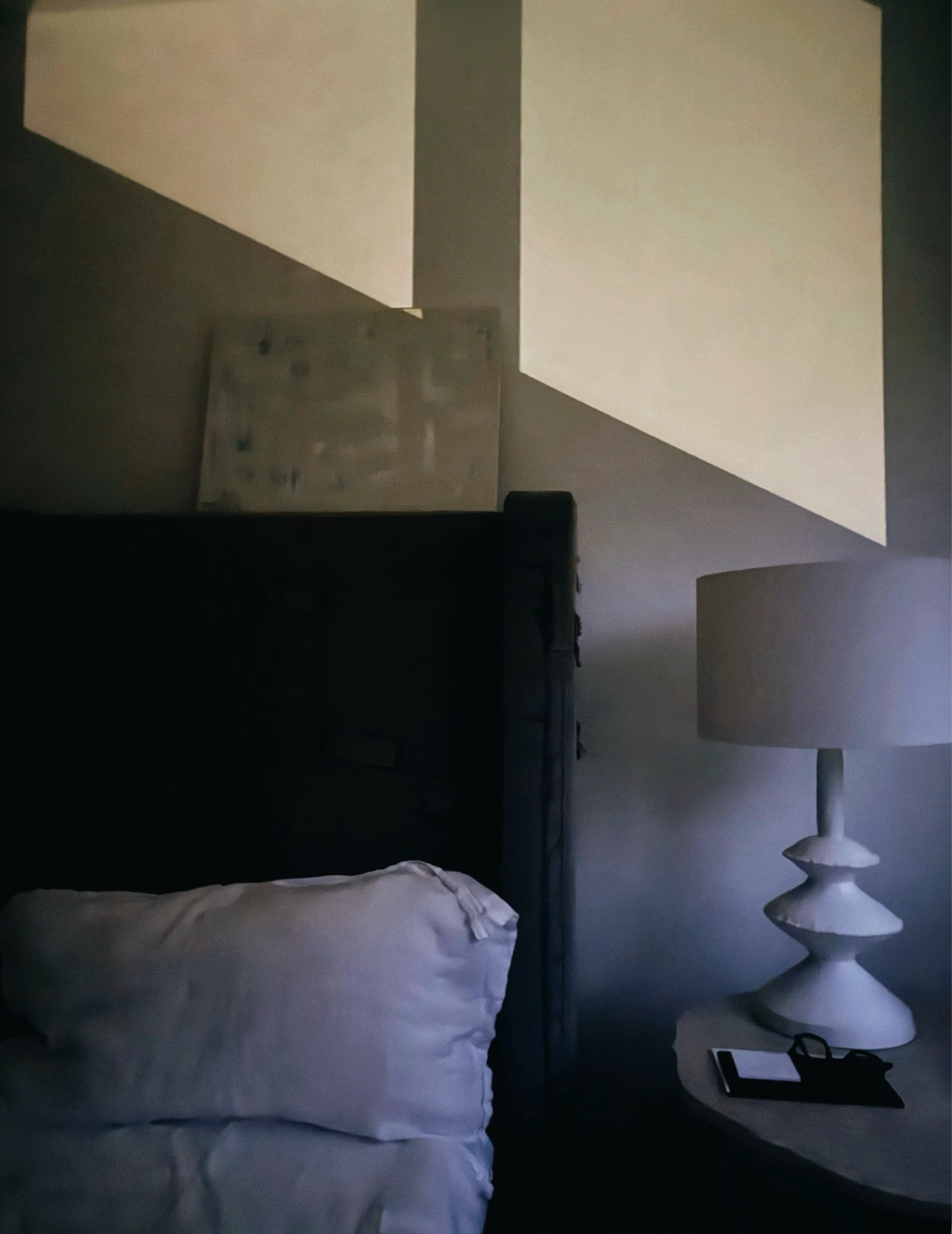 Night lights casting striped and blocked shadows across a bed and white bedroom wall.