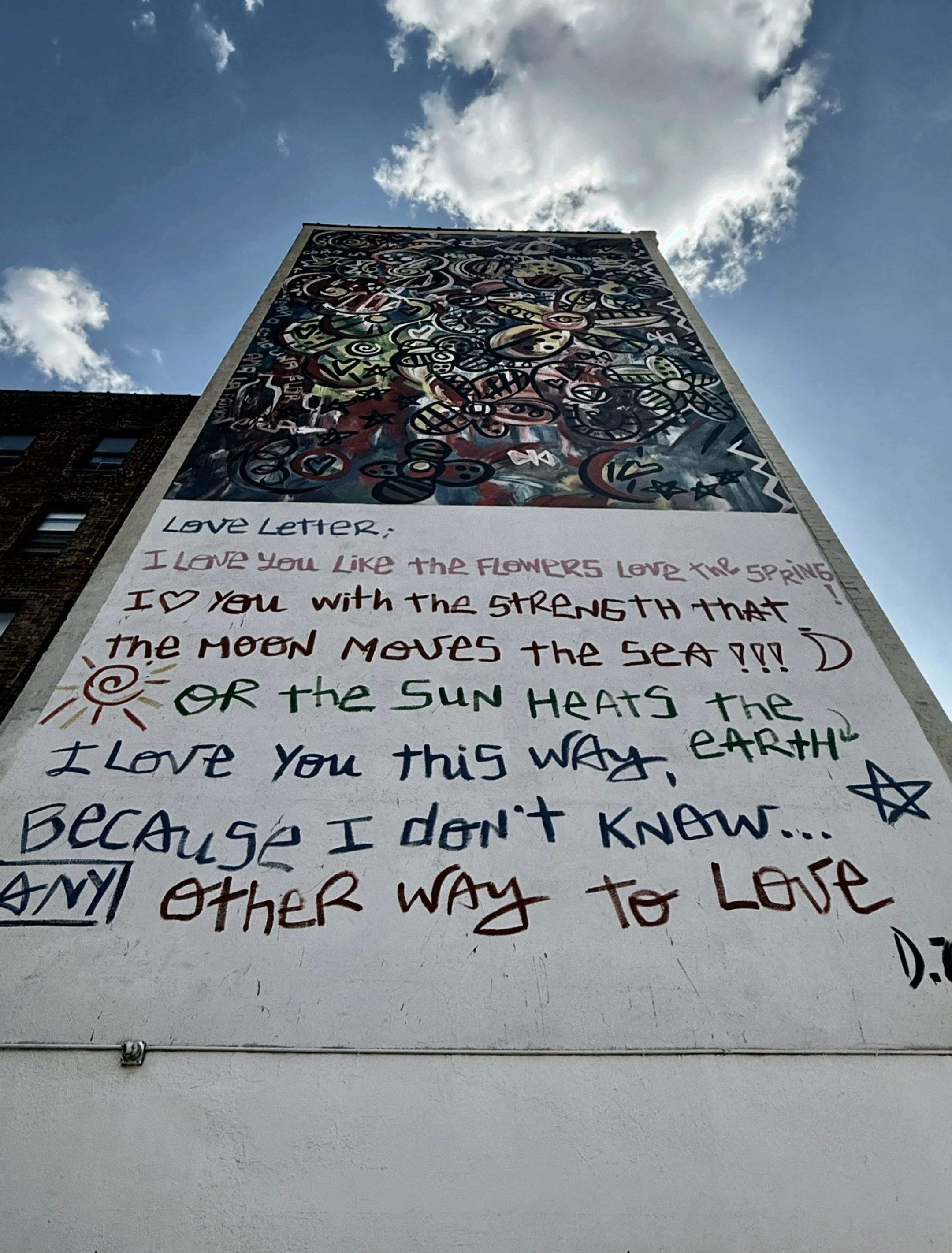 Mural featuring a handwritten poem painted on a building wall in New York City.