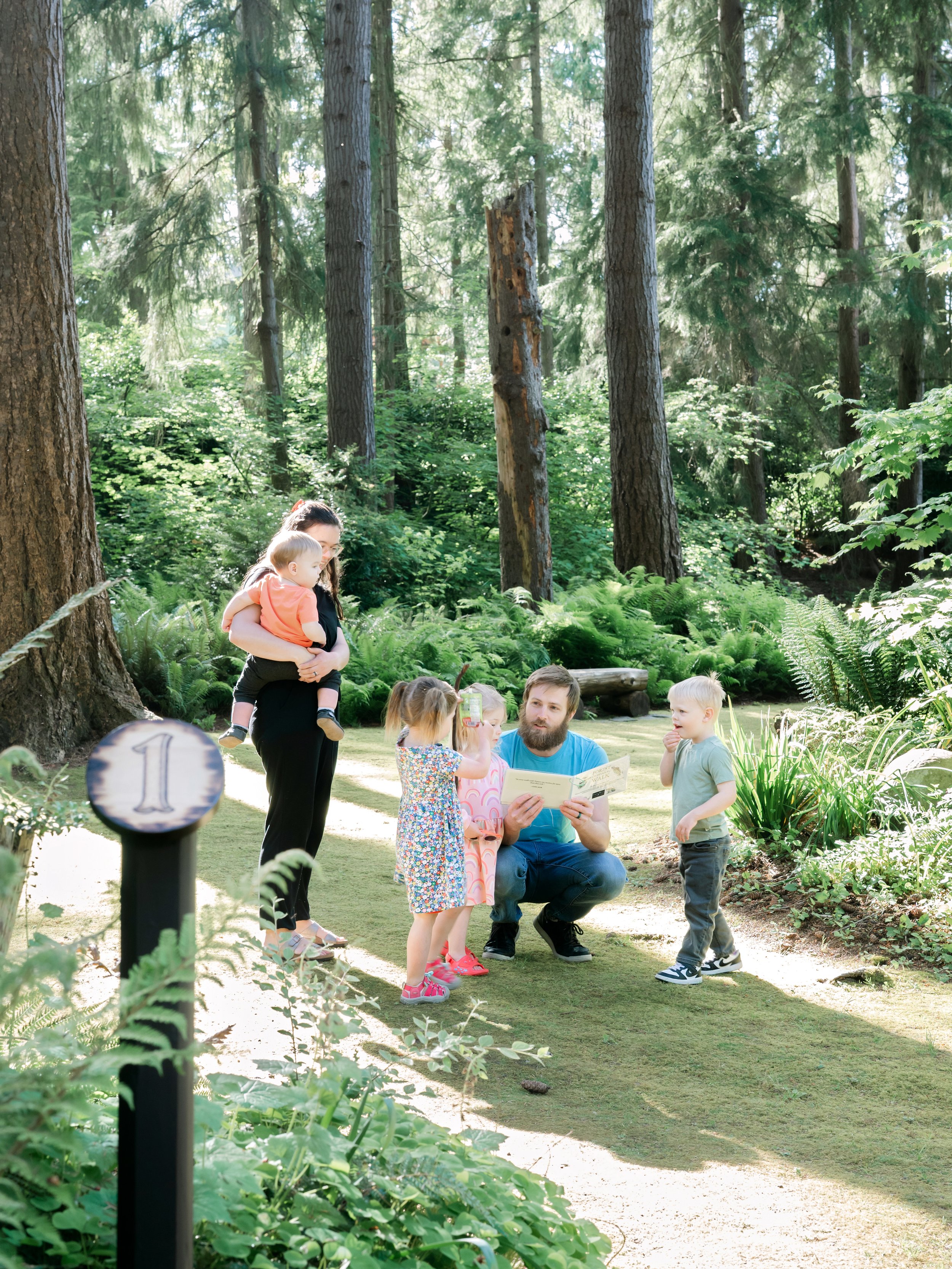 A family pauses at the first stop on the PowellsWood Forest Observation Walk
