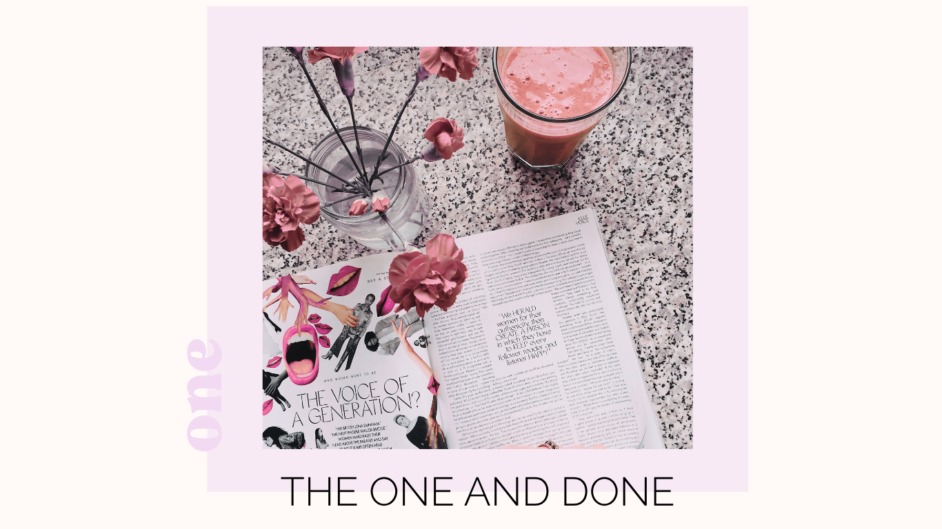 Magazine open on a speckled countertop with pink flowers in a glass vase, a pink smoothie, and a magazine titled 'The Voice of a Generation'.