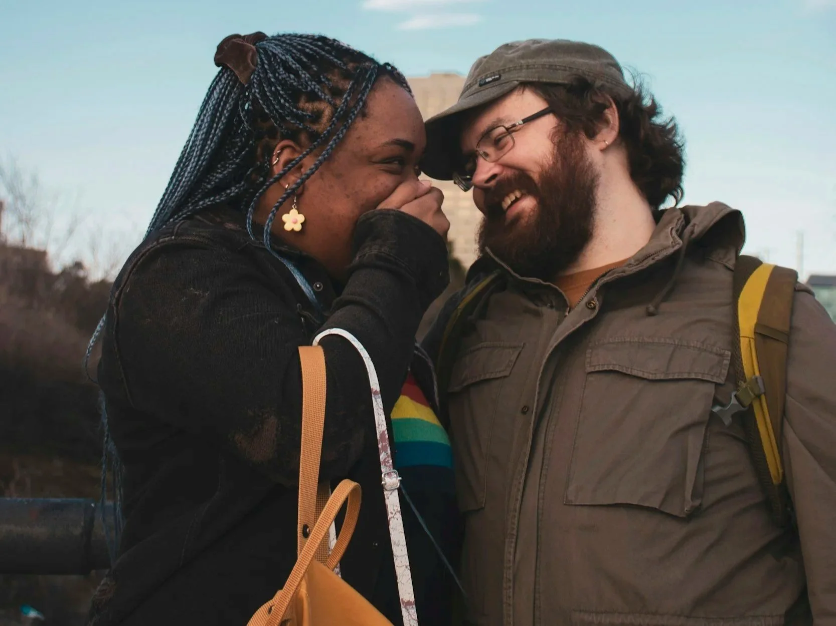 interracial couple laughing together outside