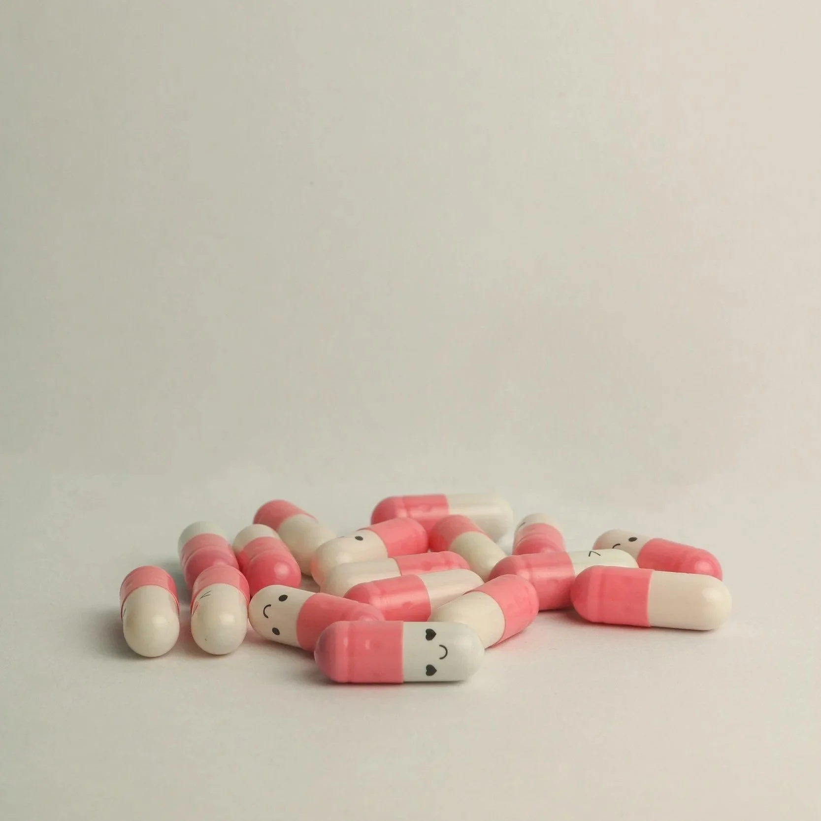 pink and white pills with happy faces on them