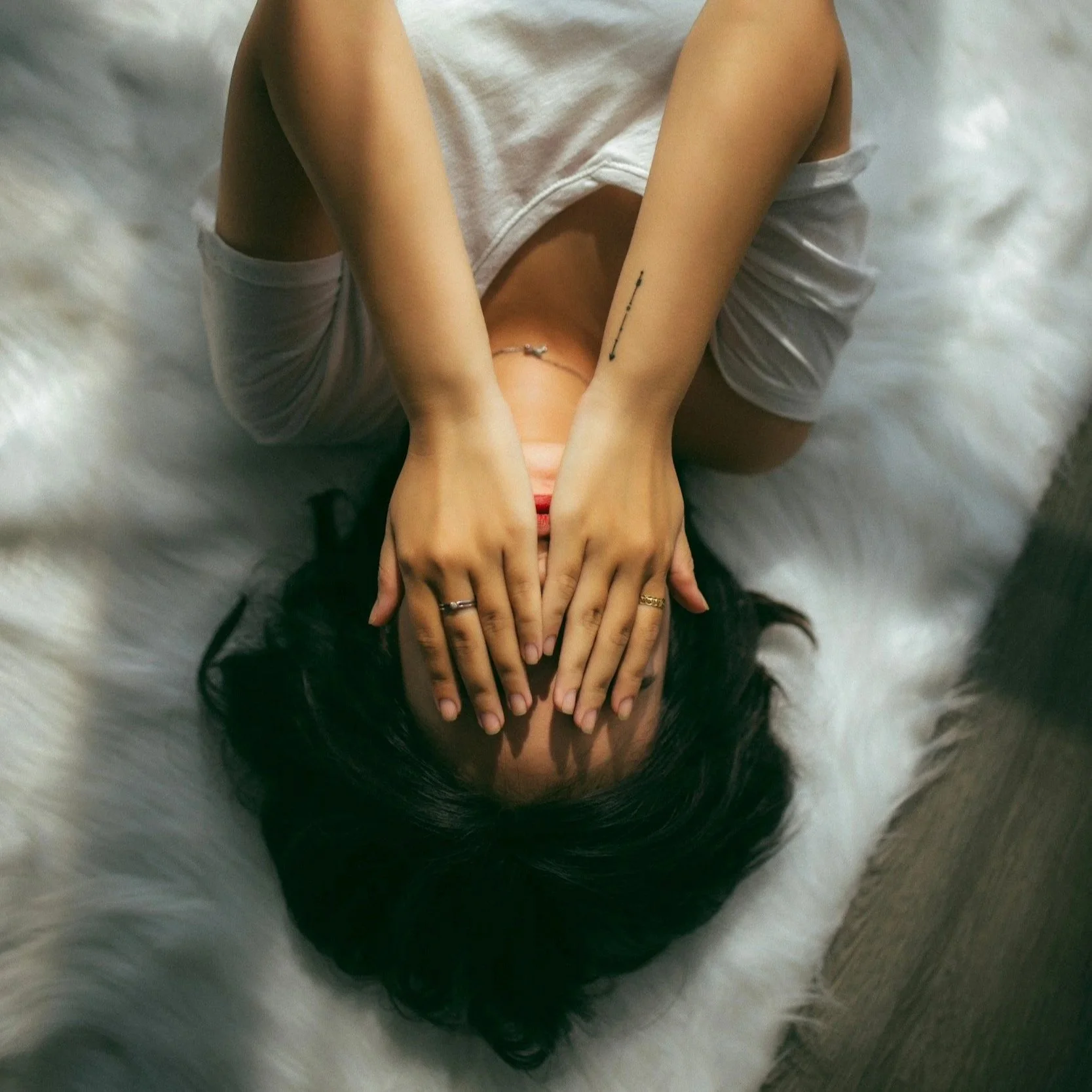 woman laying on her back covering her eyes