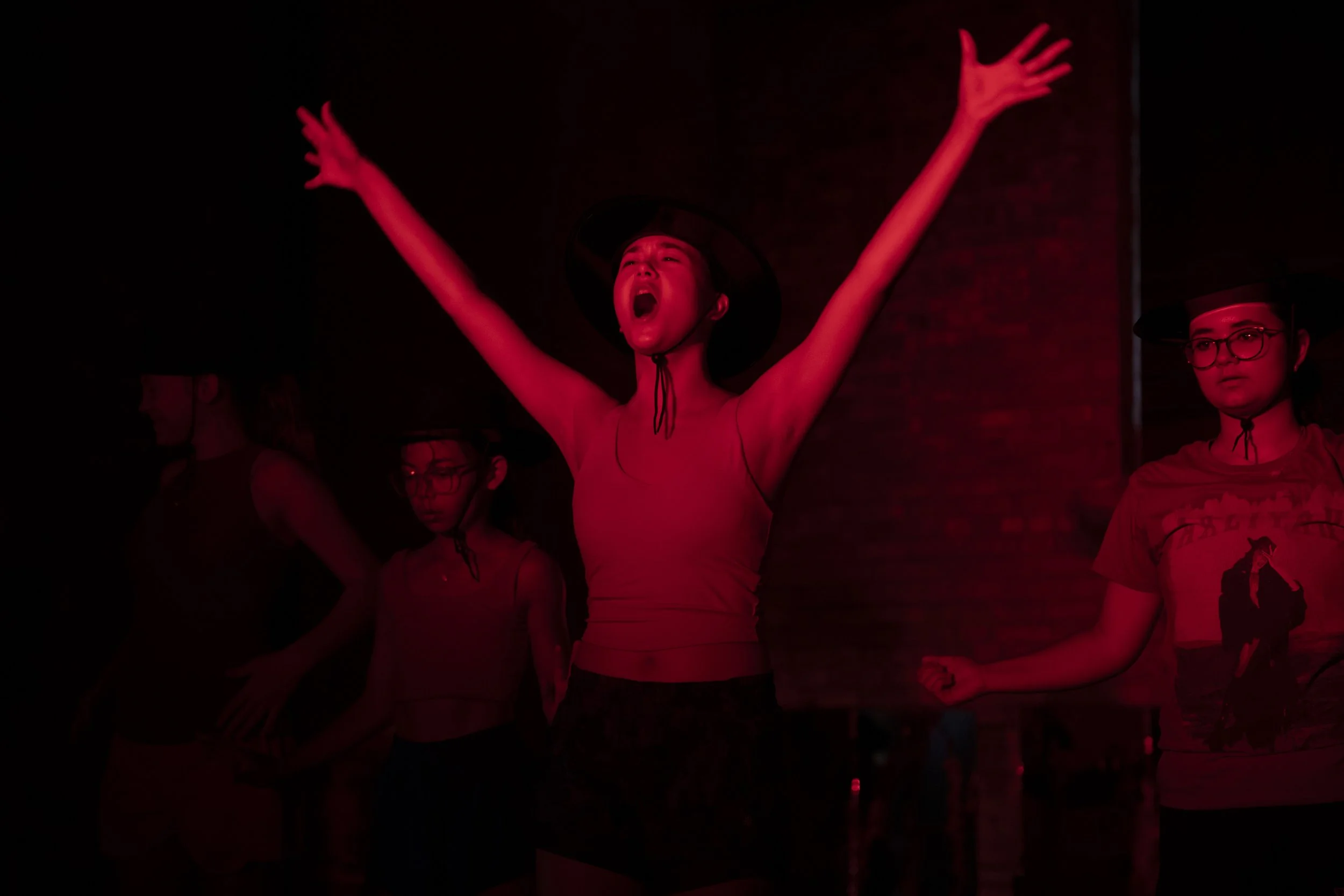 Students create a heart with their hands during a performance