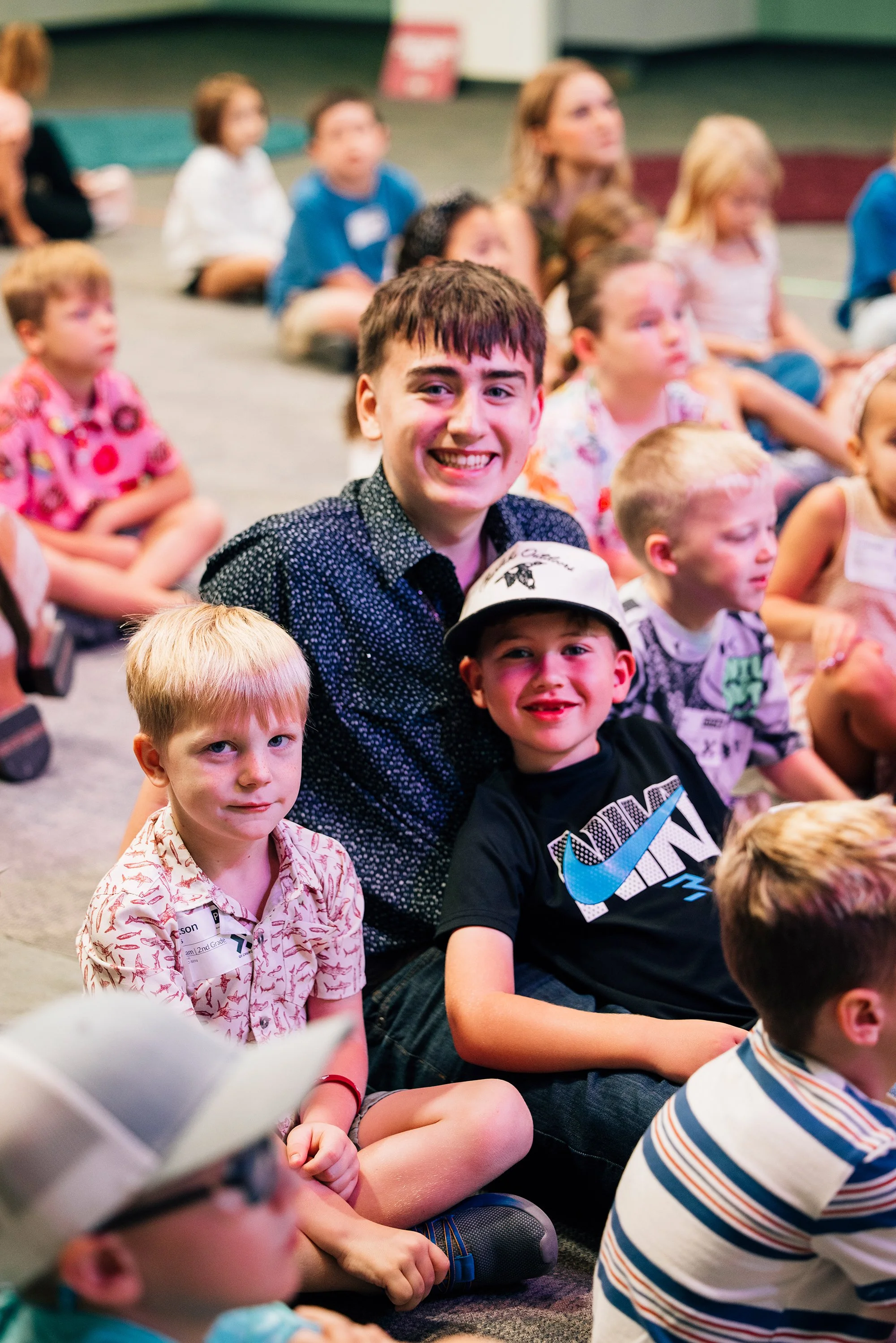 Smiling children and teenagers gathered indoors for a group activity