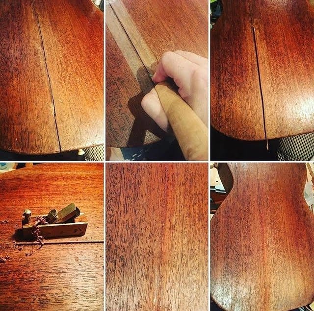 Vintage acoustic guitar repair process filling body cracks.