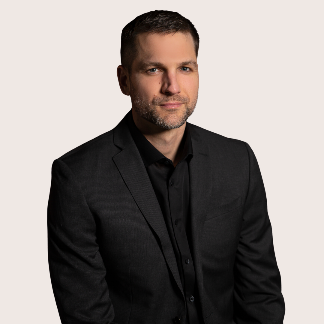 Man in a black suit with a neutral background